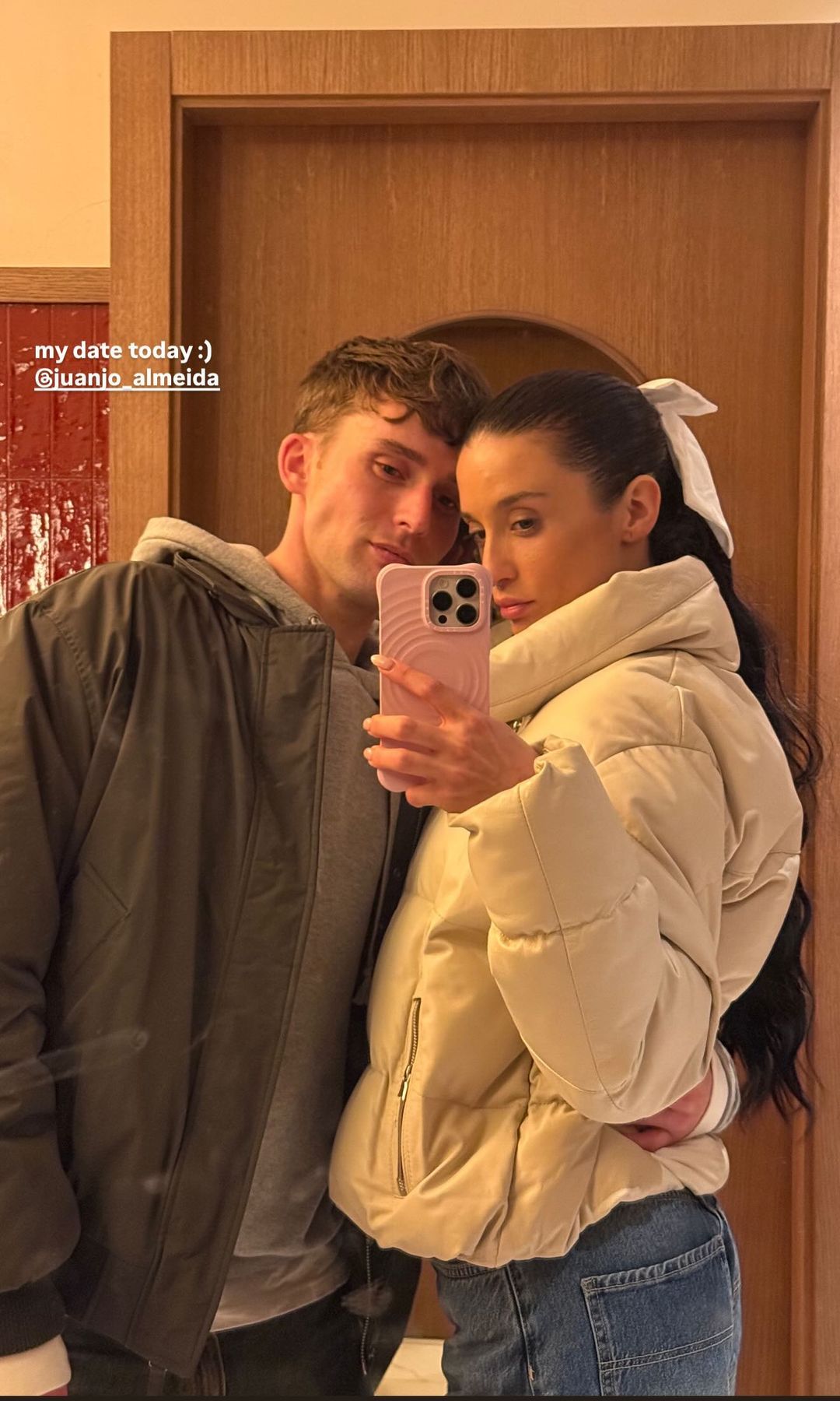 Plano medio de María Pedraza posando con Juanjo Almeida en un espejo
