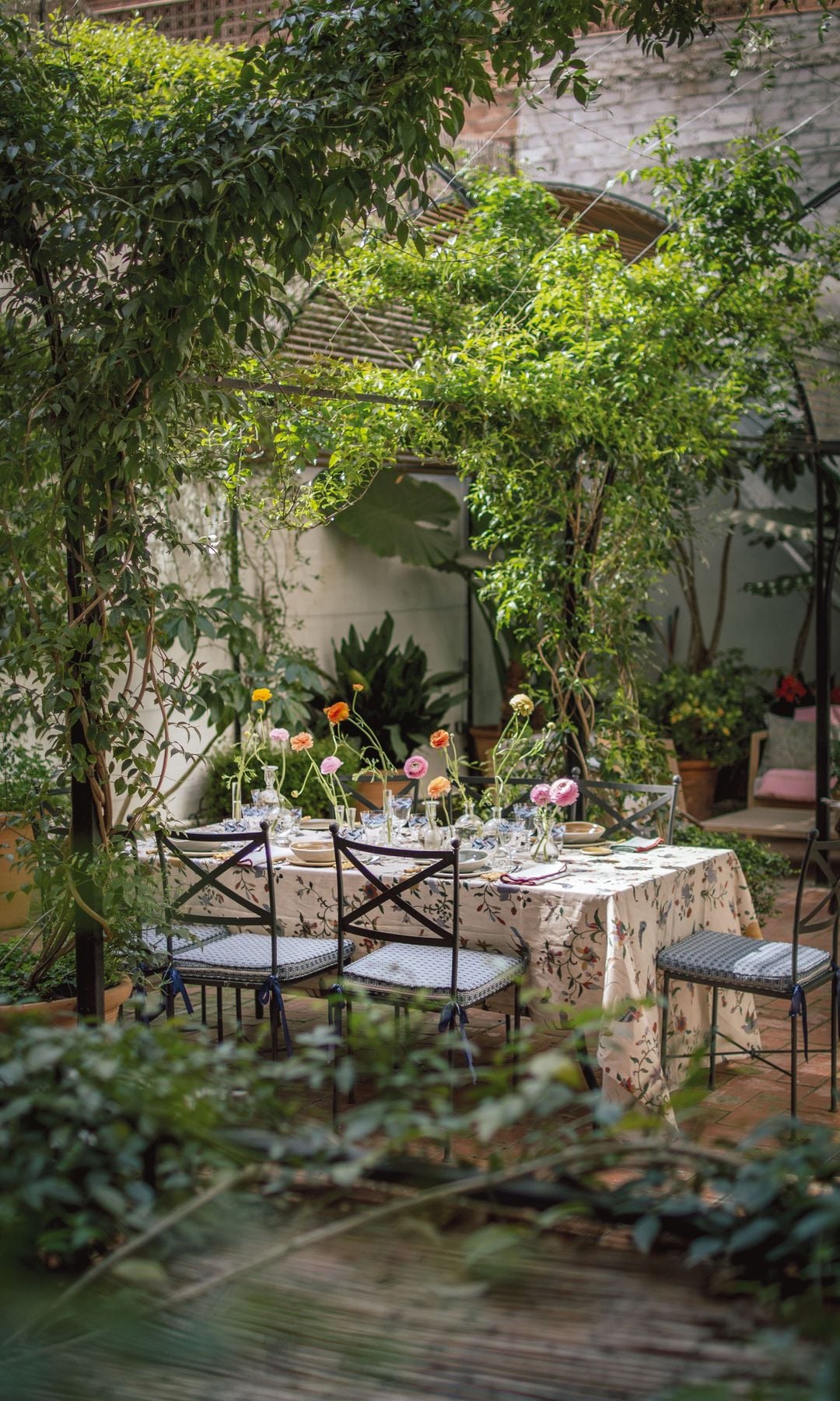 EN SU VERGEL
Vista del patio, con un comedor exterior donde almorzar y cenar durante los meses de buen tiempo, y un coqueto rincón donde la barcelonesa se relaja tomando el té, leyendo o pensando nuevas ideas. 
