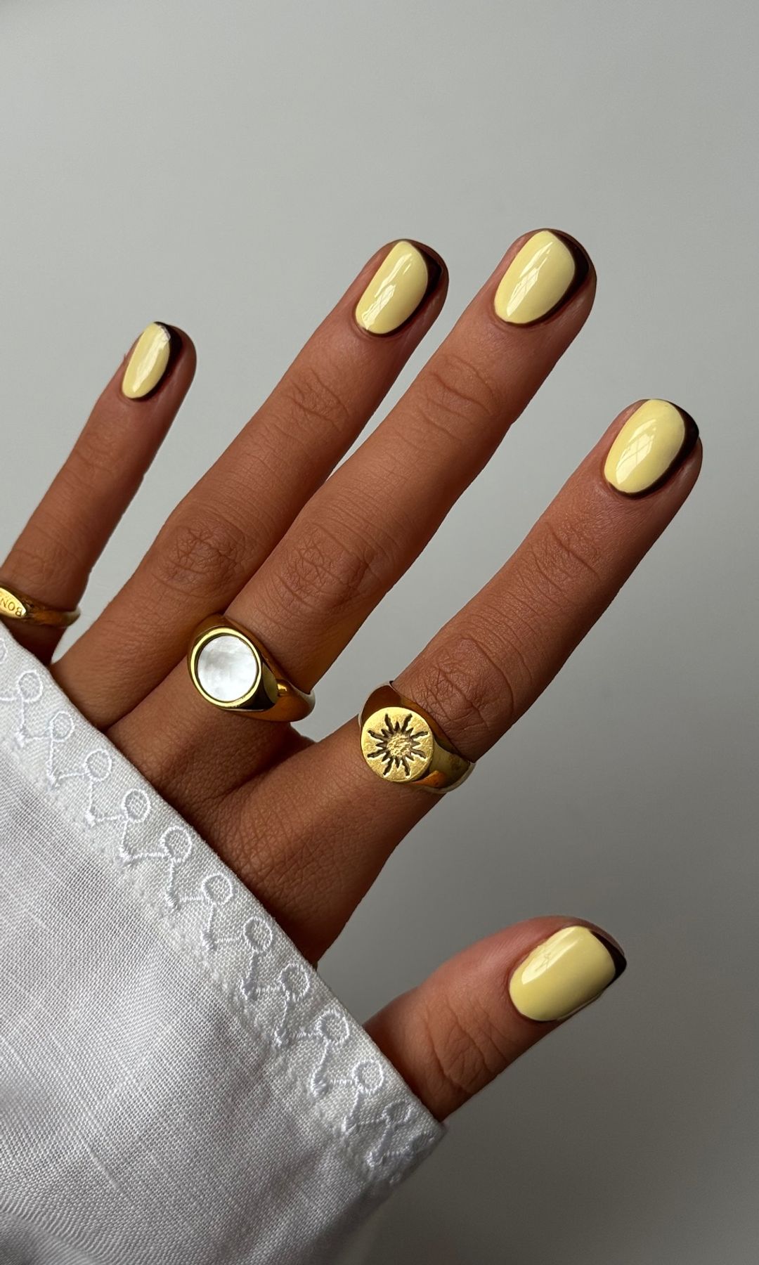 Manicura amarillo mantequilla con contorno en negro