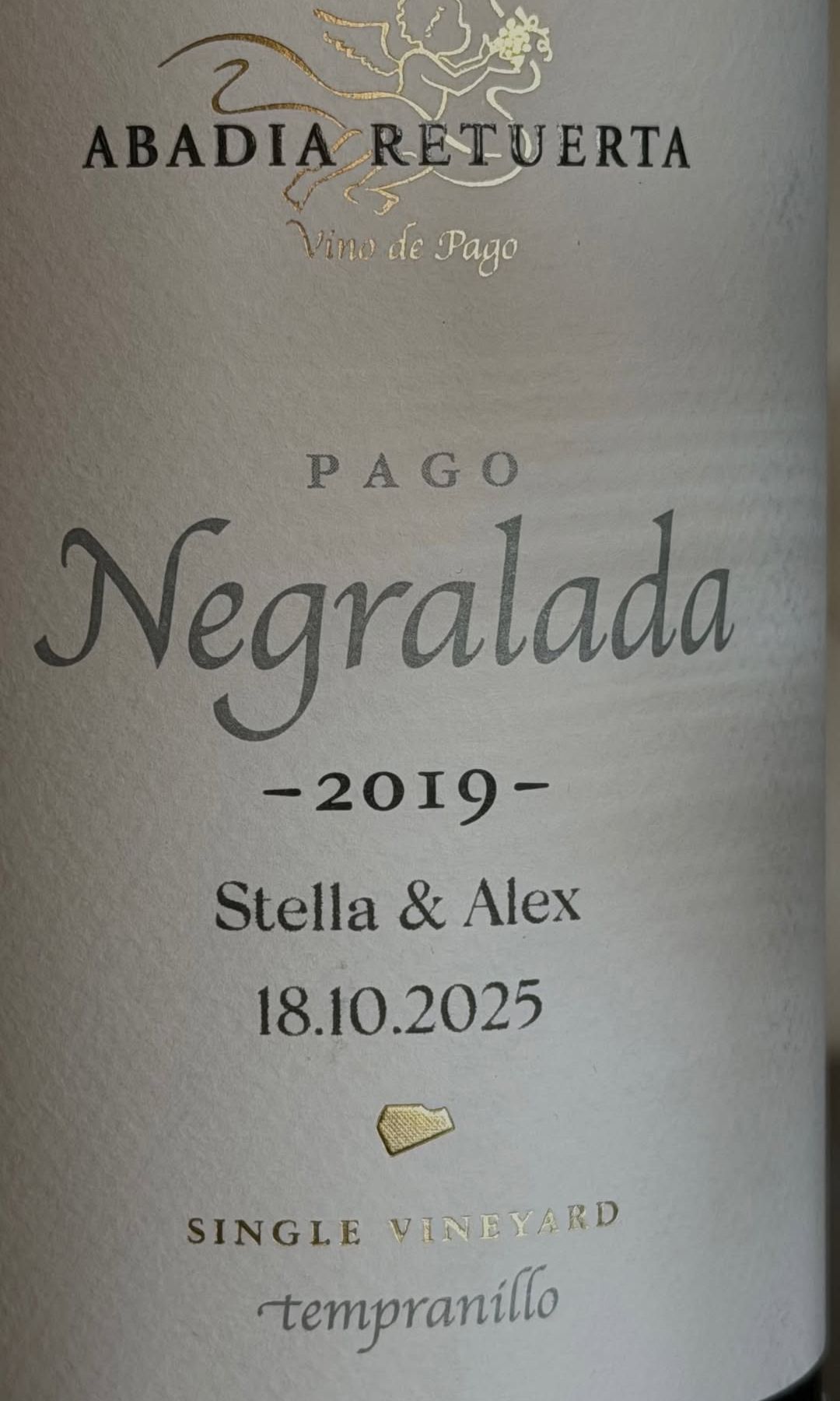 Entre los detalles más personales de la boda destaca una botella de vino de Abadía Retuerta, personalizada con los nombres de Stella y Alex y la fecha de su enlace