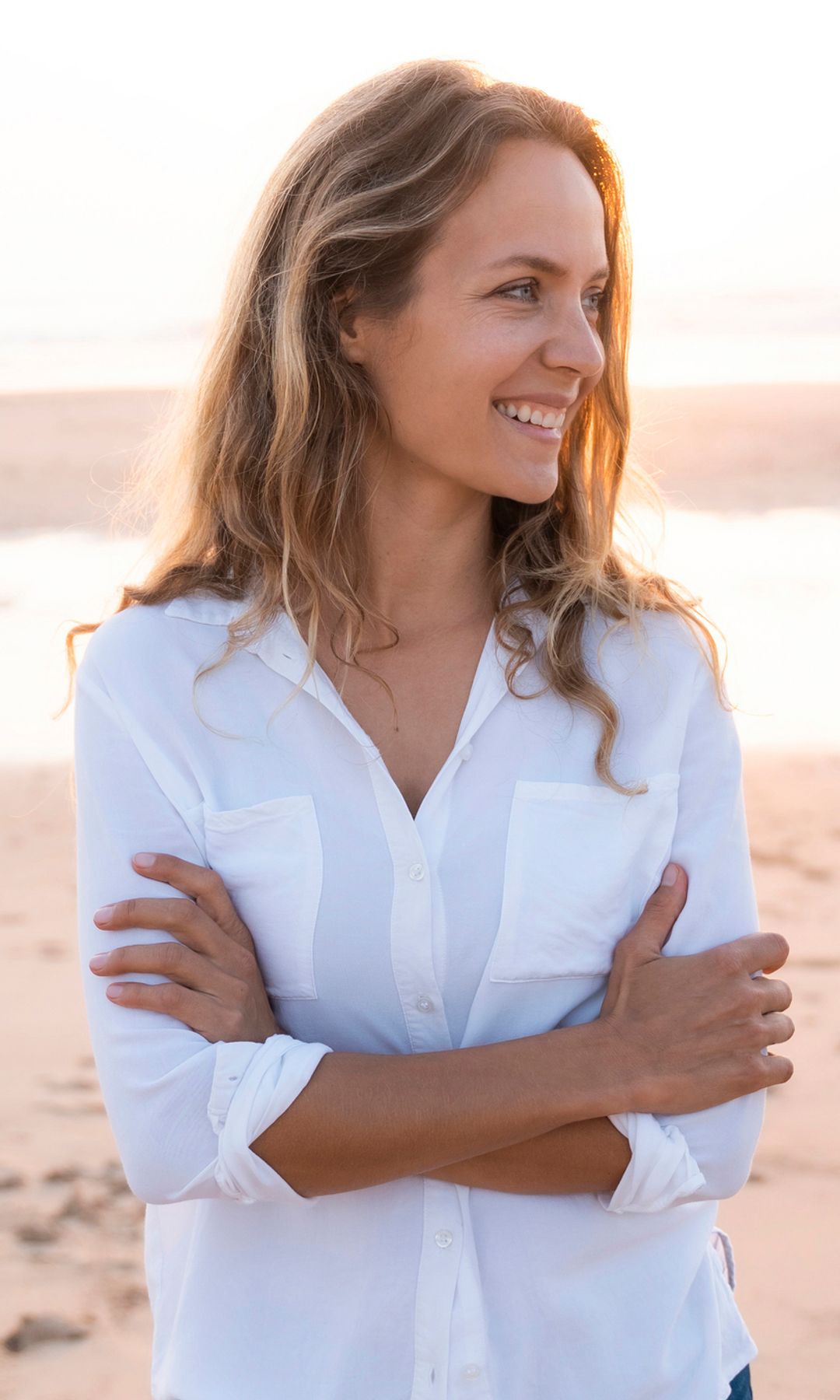 mujer sonriente sobre la arena de la playa