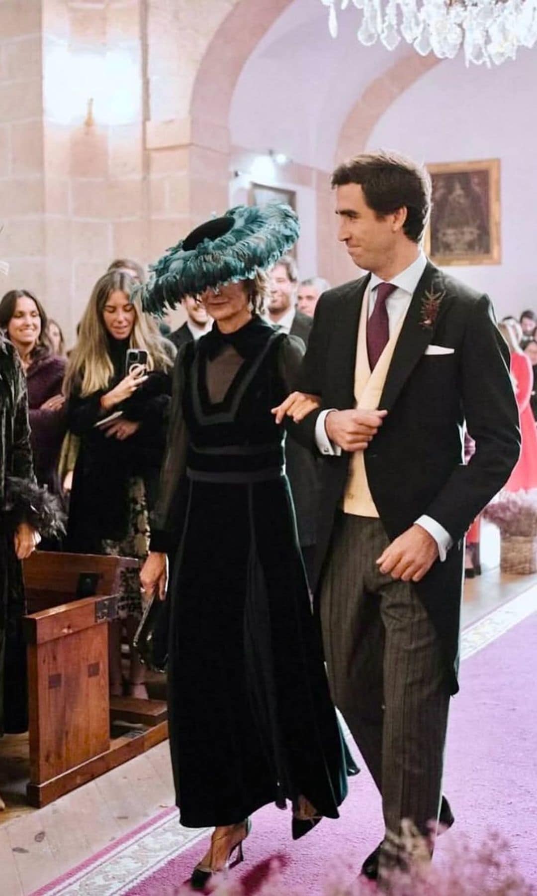Vestido de madrina de Teresa Helbig y pamela de plumas de Conchitta