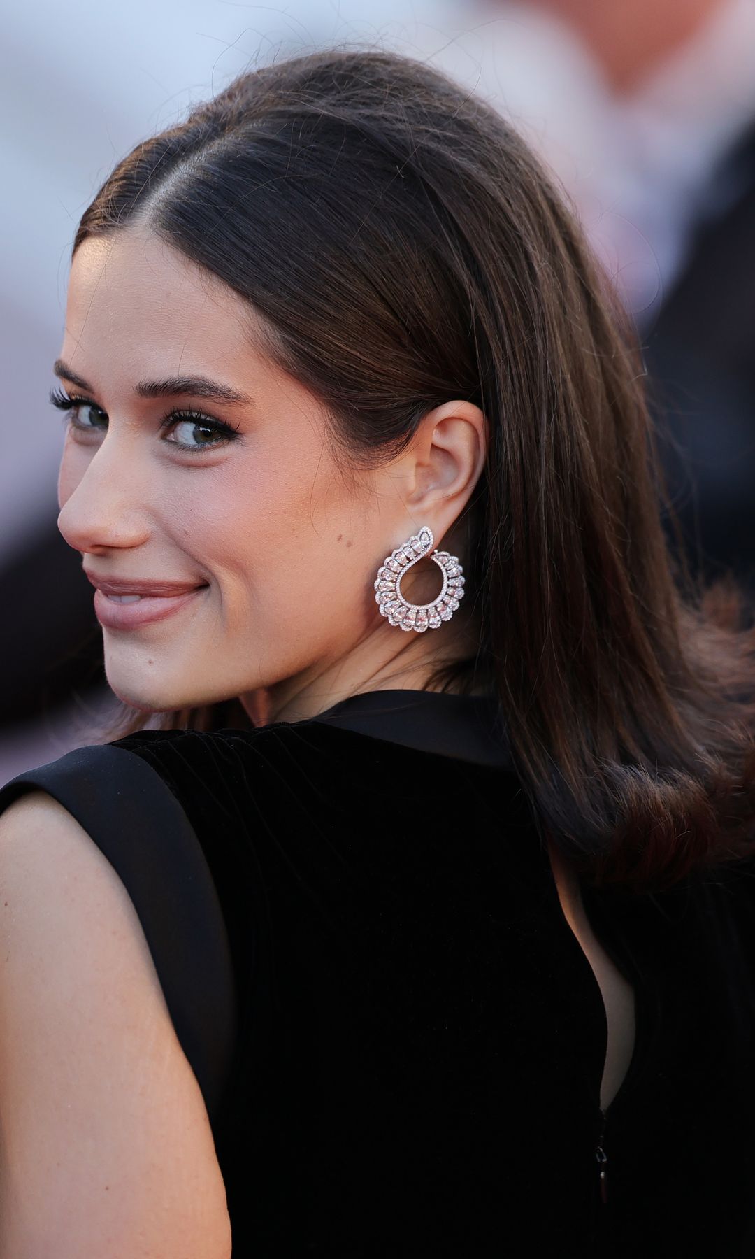Ella Travolta posa en la alfombra roja de Cannes con vestido negro y melena de inspiración retro.