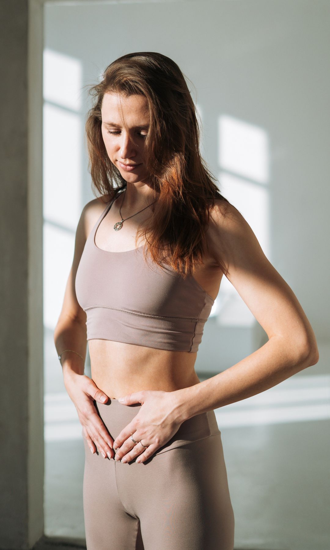 Mujer en ropa deportiva tocándose el vientre