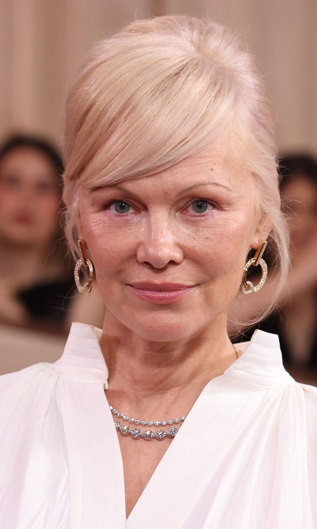 Pamela Anderson con recogido rubio frío y maquillaje natural en los Globos de Oro 2026
