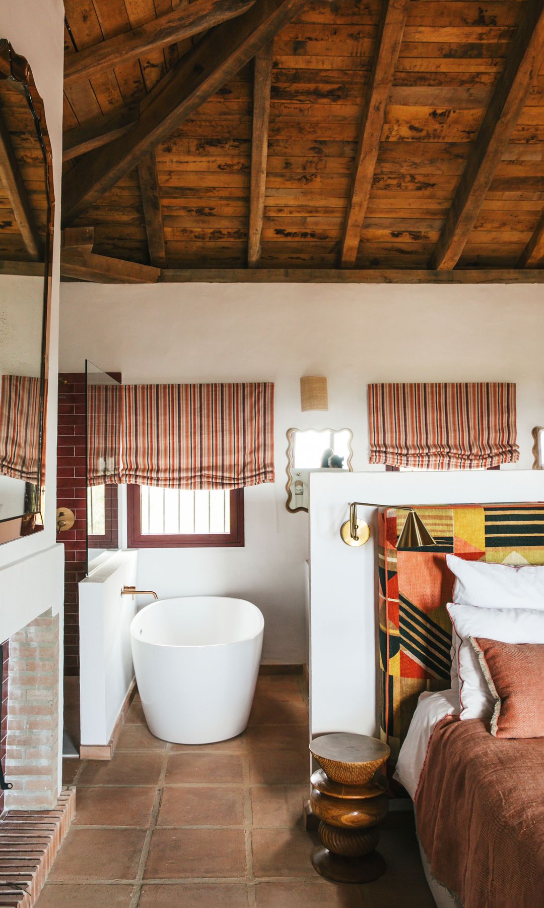 Uno de los dormitorios de la vivienda. La cama tiene un cabecero con tela Zimmer & Rhode. La mesilla es de Heaps & Wood y las cortinas, de Pierre Frey