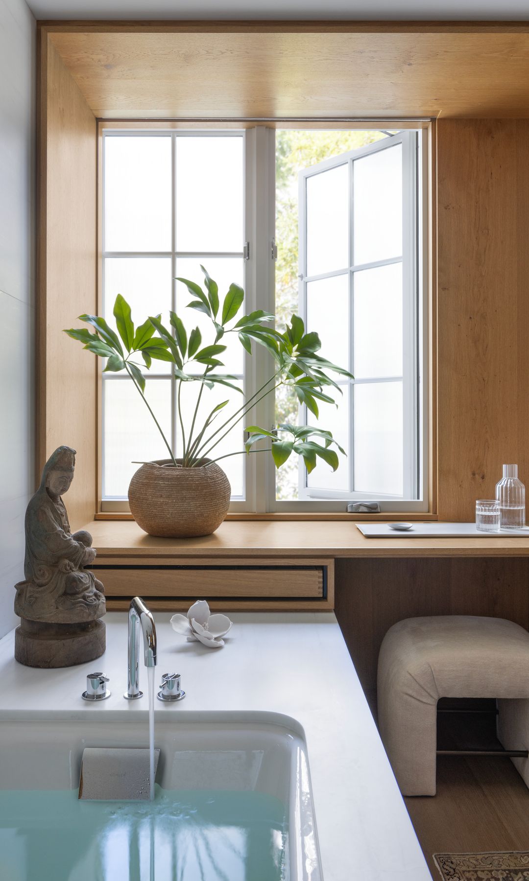 Baño de estilo japandi, con bañera, planta, zona de tocador 