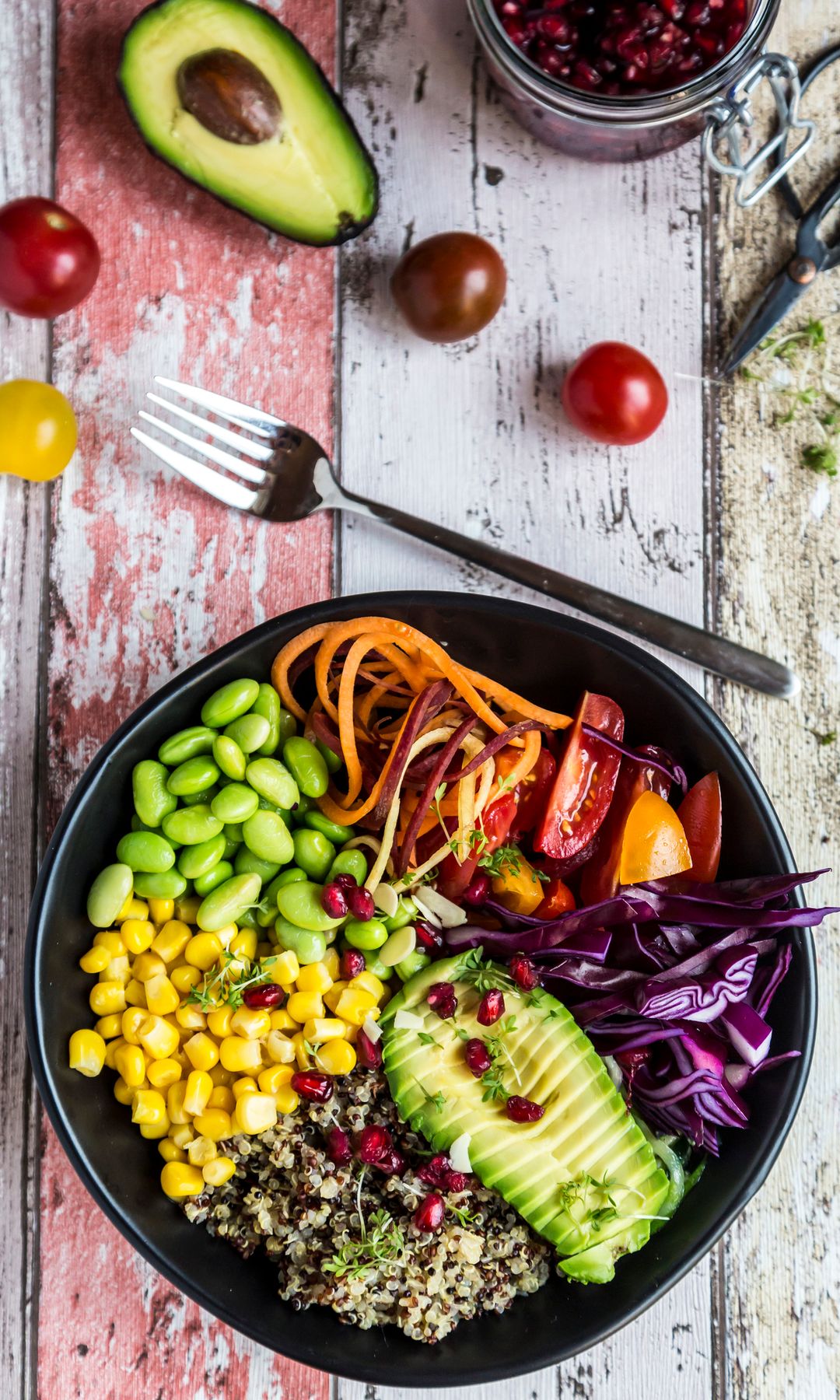 Plato de comida saludable con aguacate, edamame, maiz, y quinoa