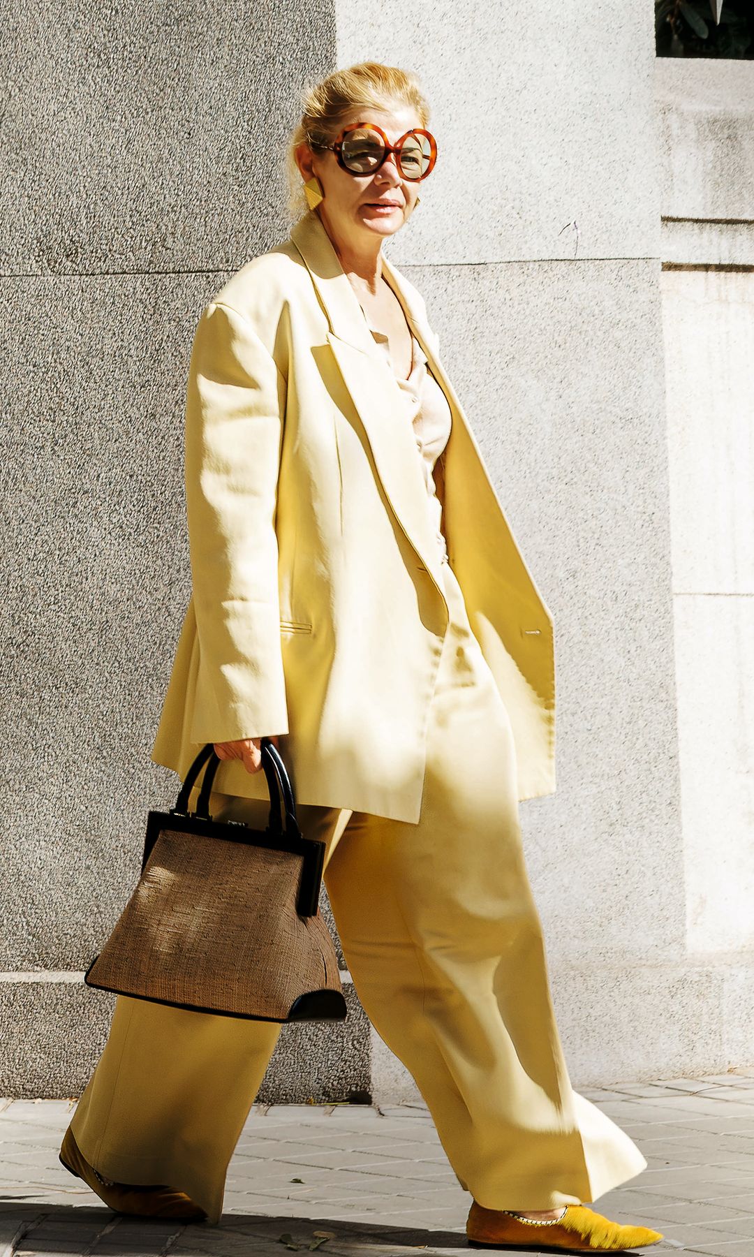 Lady Elena Foster, tan estilosa como siempre, con un conjunto de dos piezas en amarillo pastel y con sus inconfundibles gafas de sol