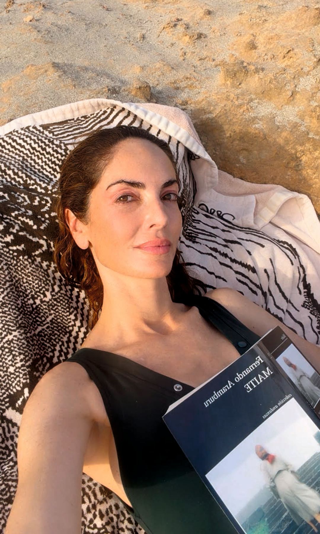 Eugenia Silva tumbada en la arena leyendo Maite