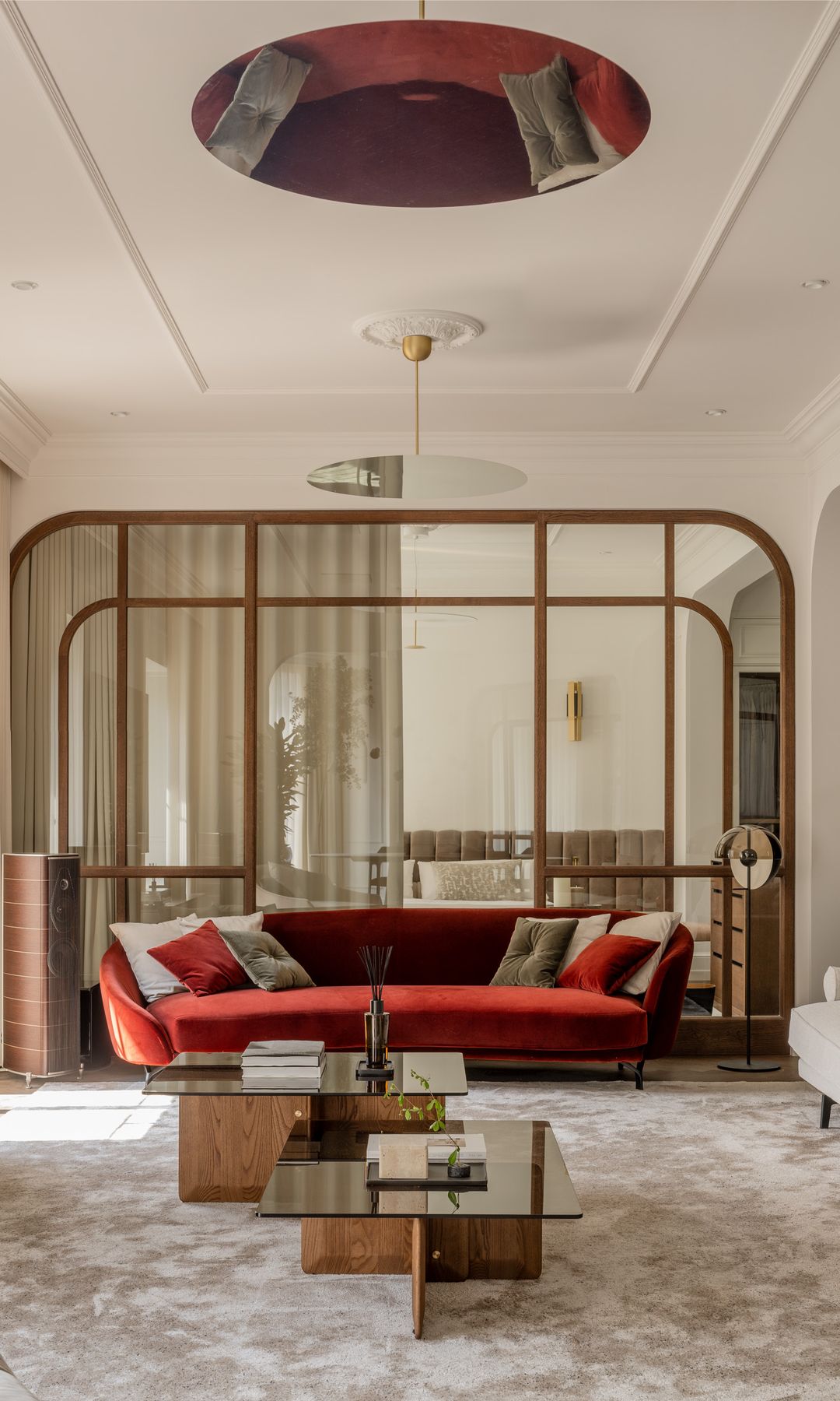 Salón con vidriera con marco de madera, sofá rojo, alfombra, molduras en el techo