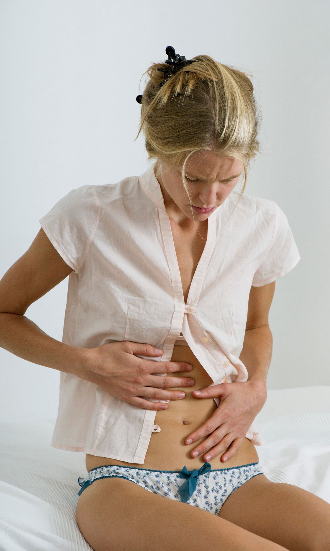 Mujer tocándose la tripa