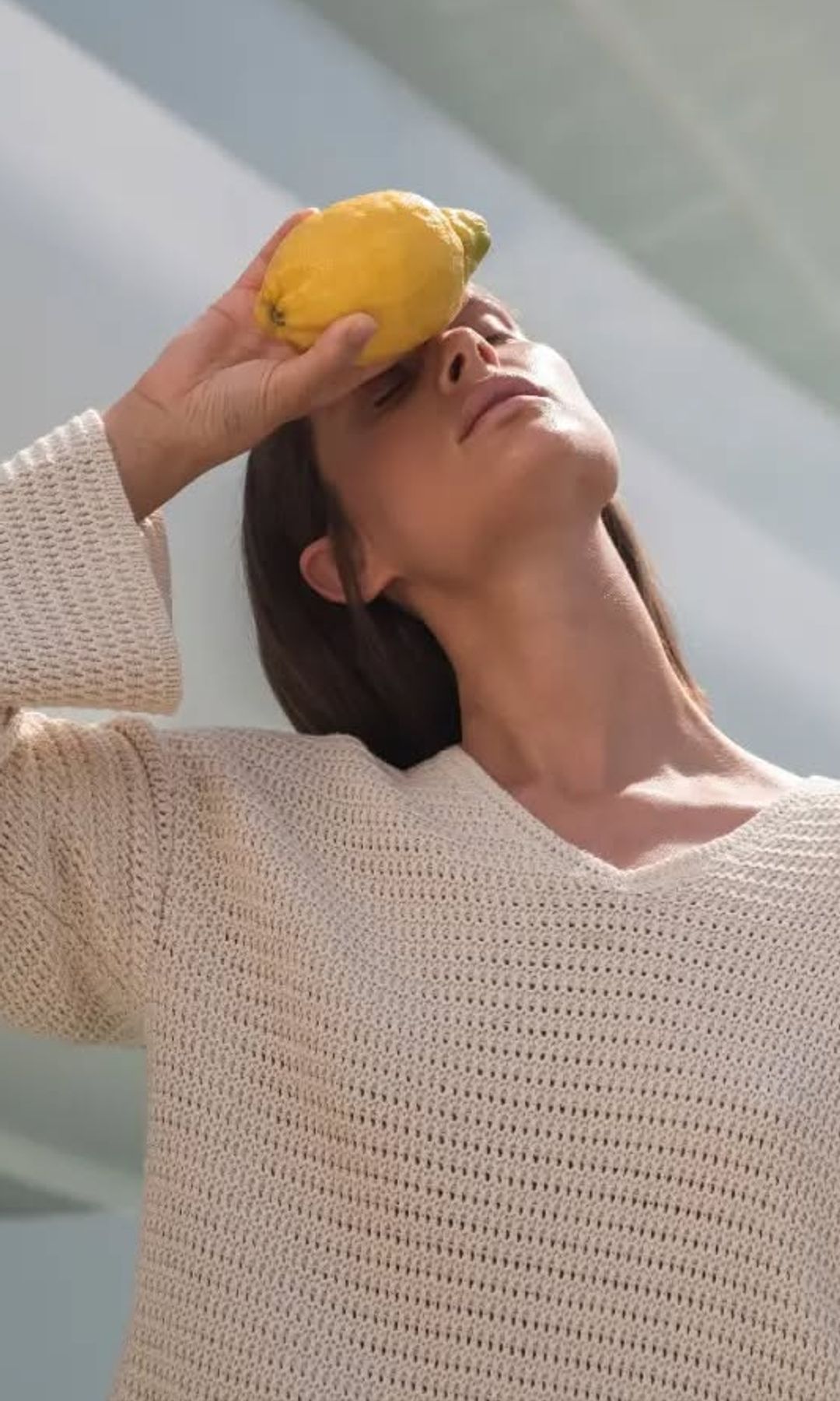 Una mujer tranquila con un limón en la mano que cuida su nutrición