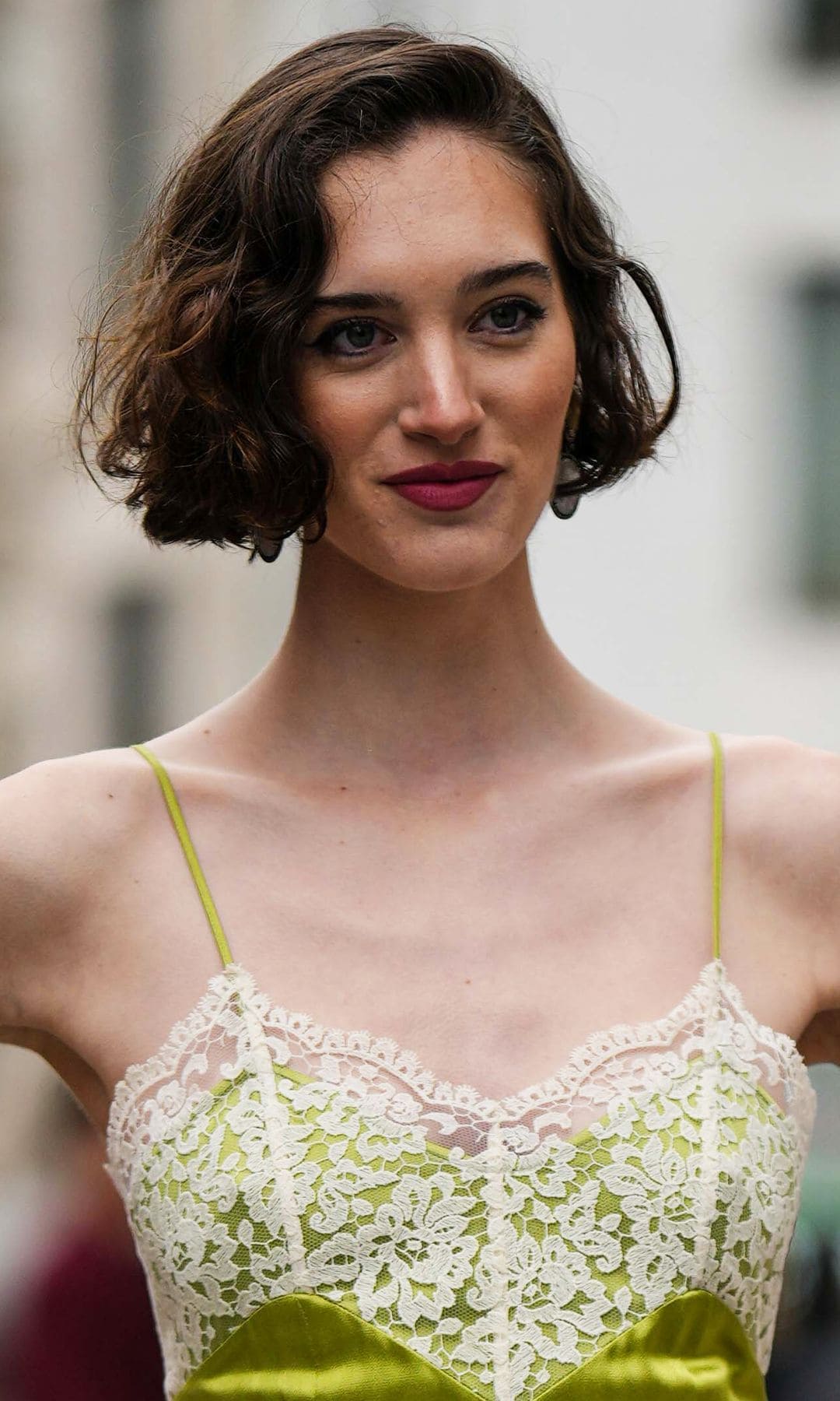 Invitada Semana de la Moda de Nueva York con vestido lencero verde lima, pelo corto y tacones de pulsera