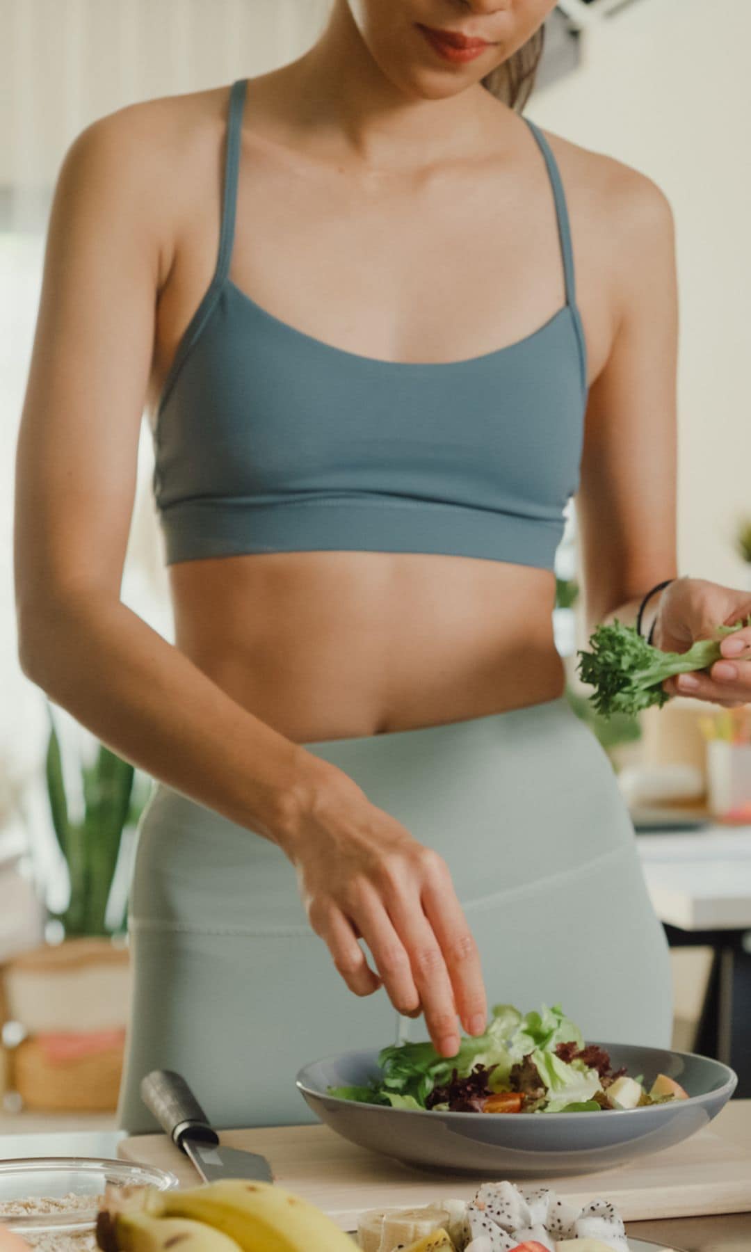 Una mujer preparándose una ensalada con los ingredientes de la dieta keto