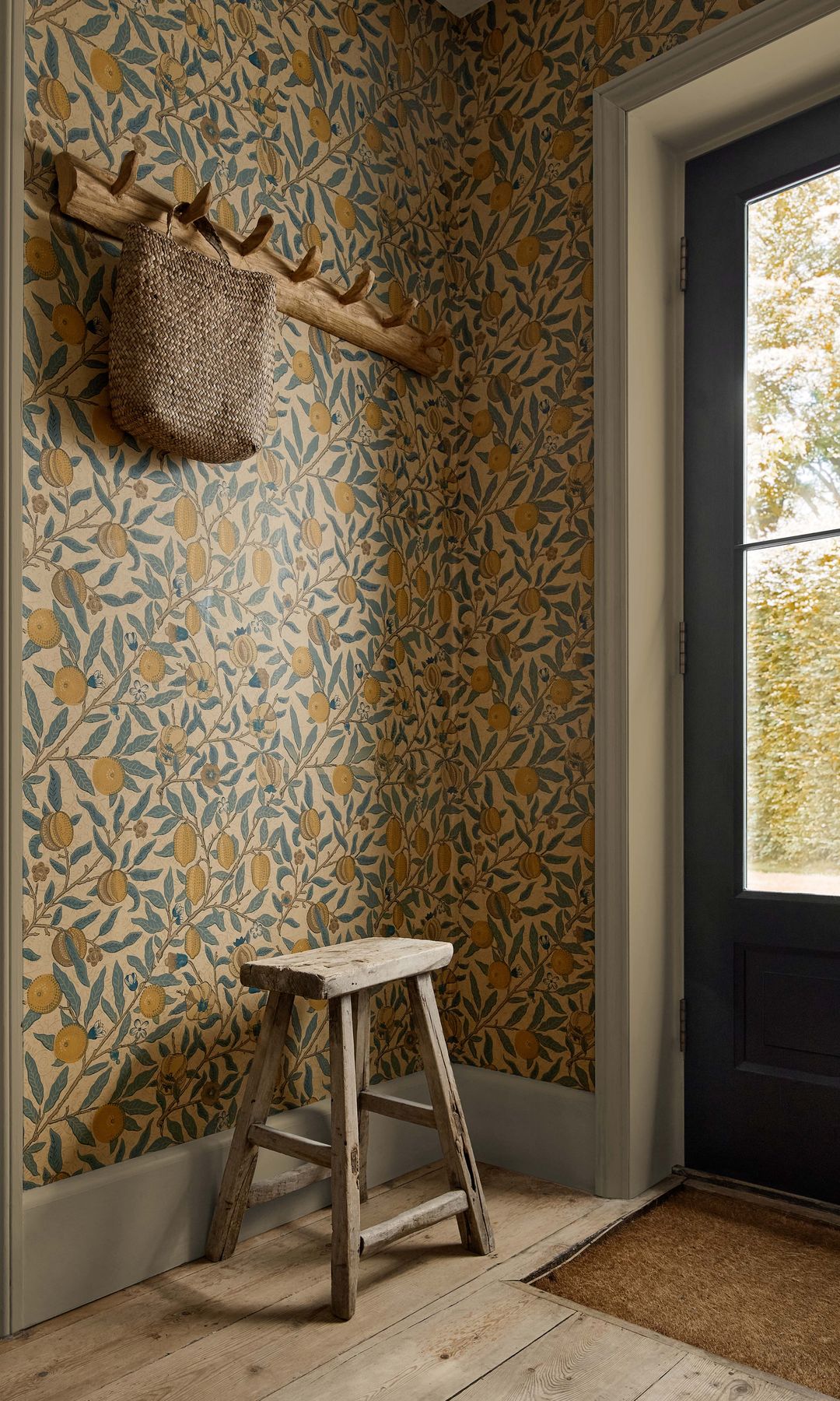 Recibidor con felpudo, papel pintado, perchero de pared, taburete de madera