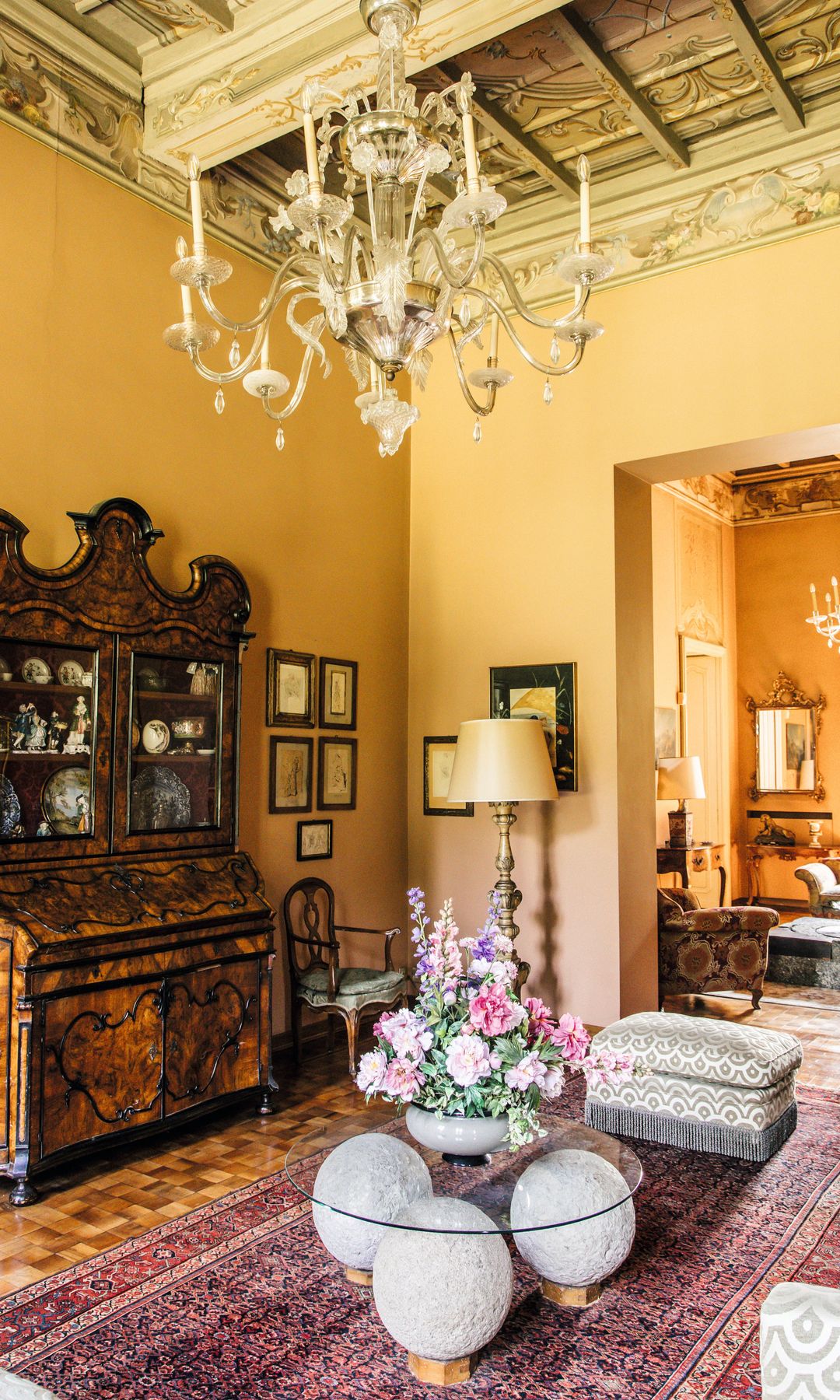 Otra imagen de la estancia y del salón contiguo, ambos con falso techo de madera y lámpara de cristal de Murano