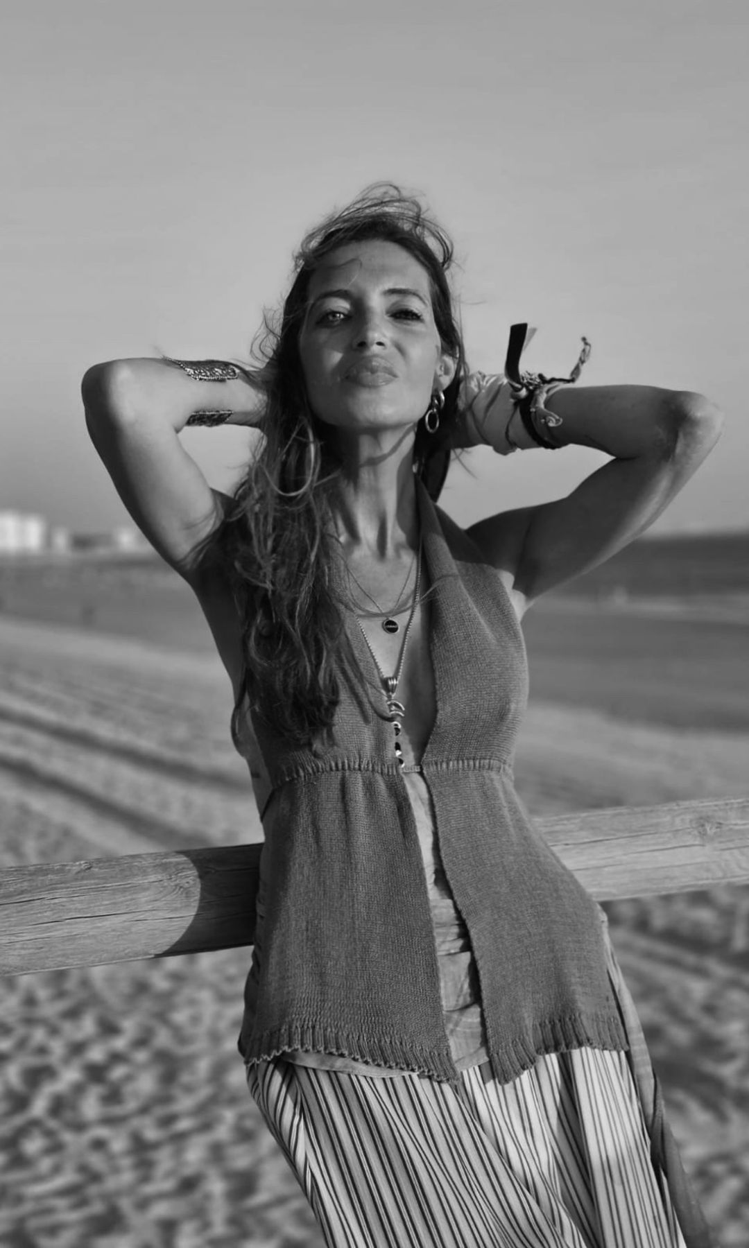 Foto en blanco y negro de Sara en la playa con top abierto en la parte frontal