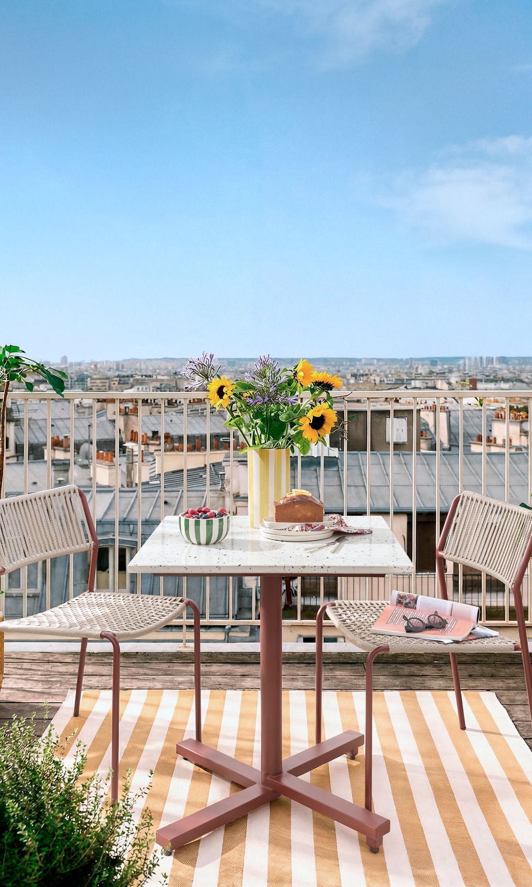 Terraza pequeña con alfombra y jarrón a rayas