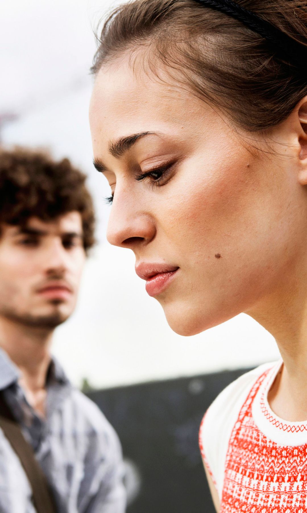 Mujer triste con su pareja detrás 