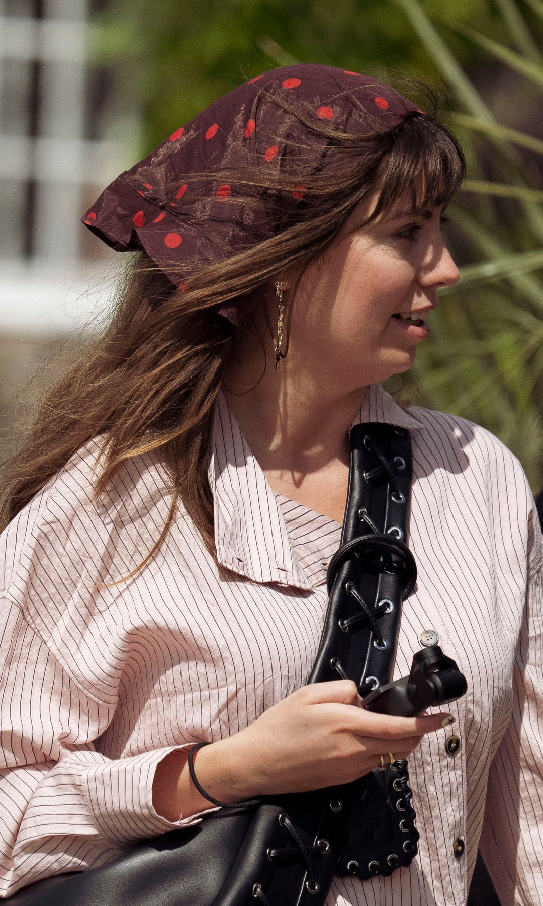 Invitada a la Semana de la Moda de Copenhague con gabardina y pañuelo en la cabeza