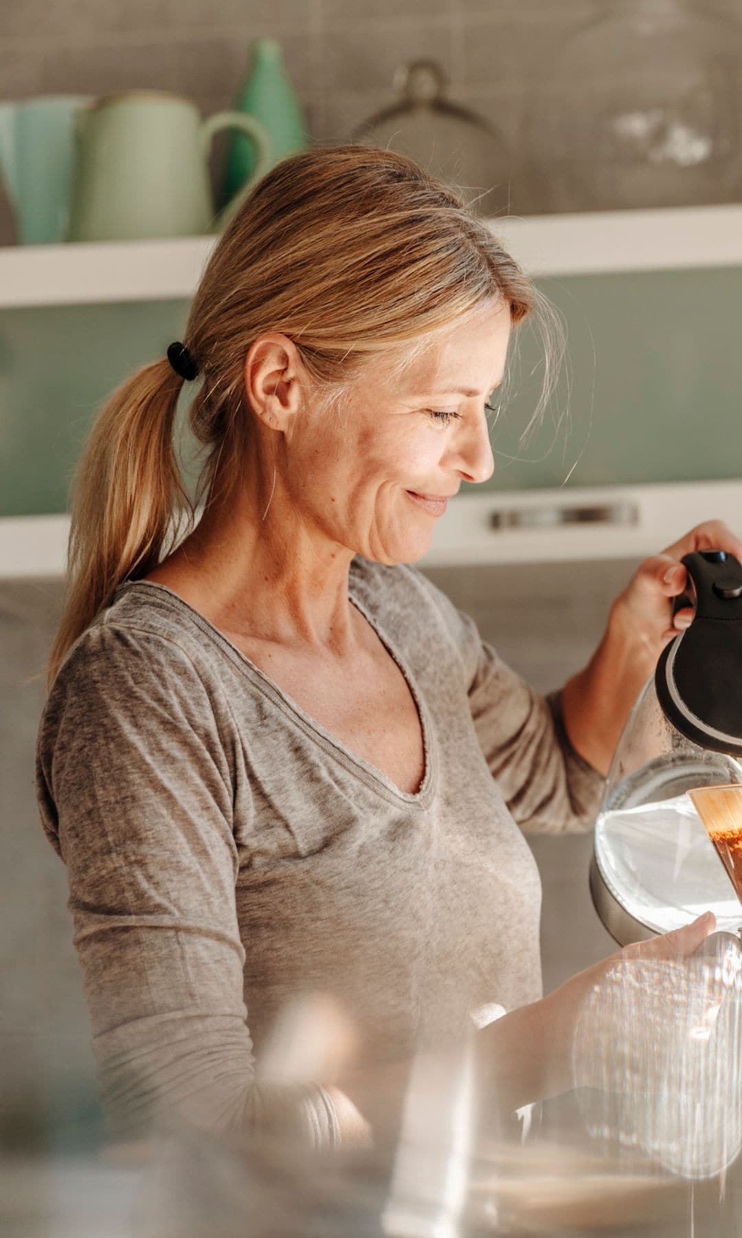 Una mujer preparándose un café por la mañana