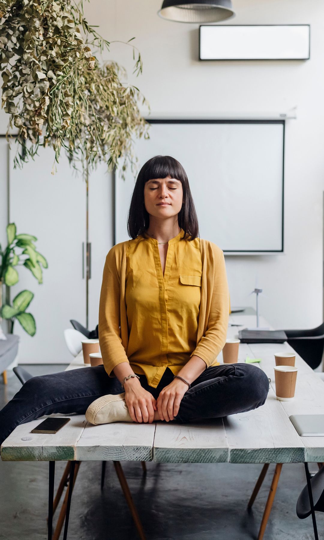 mujer meditando en una sala de reuniones de su oficina