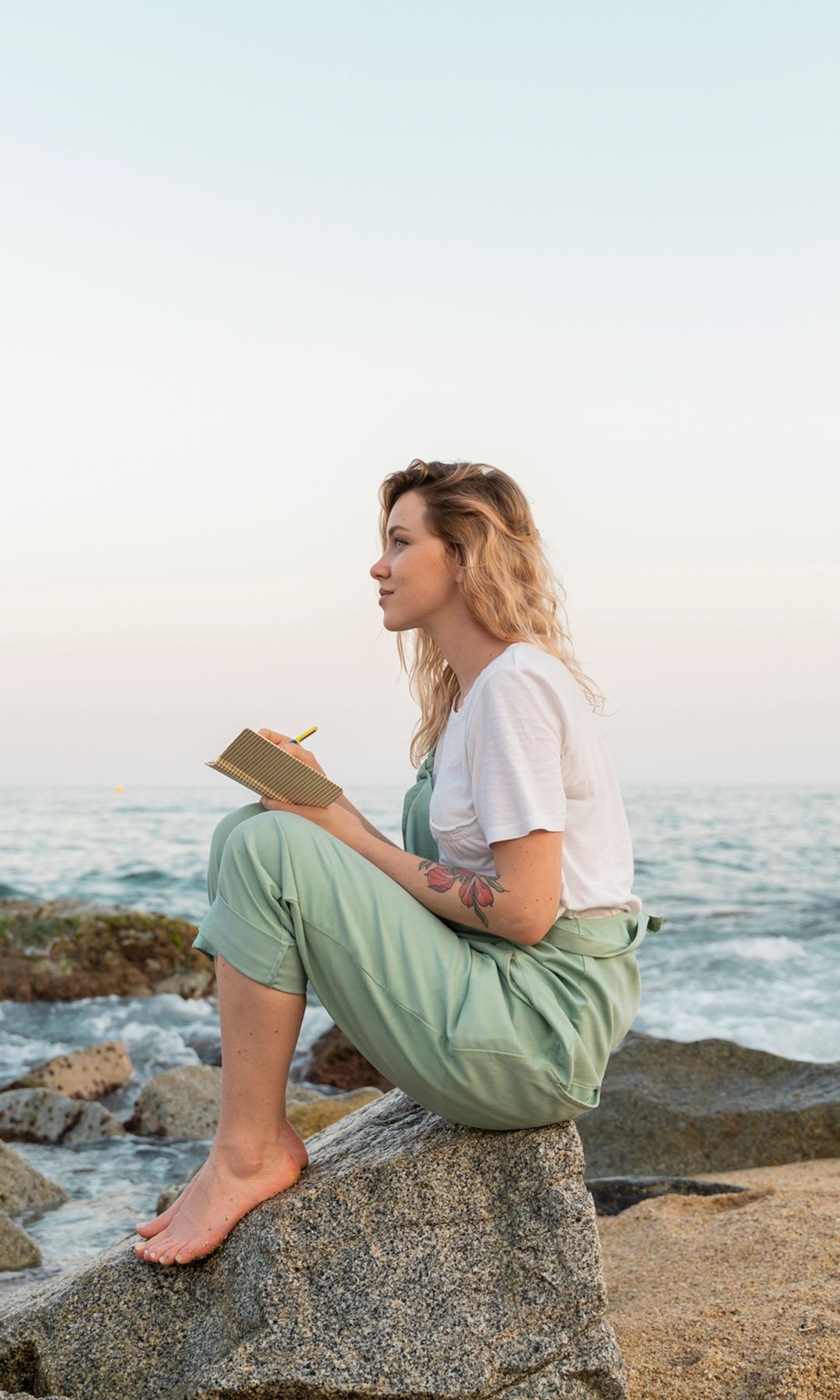Una mujer escribiendo en la playa