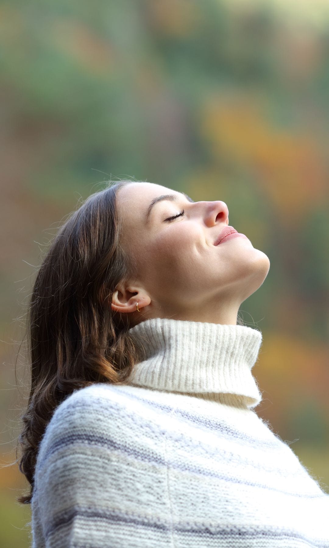 Una mujer respirando aire fresco en la montaña en invierno
