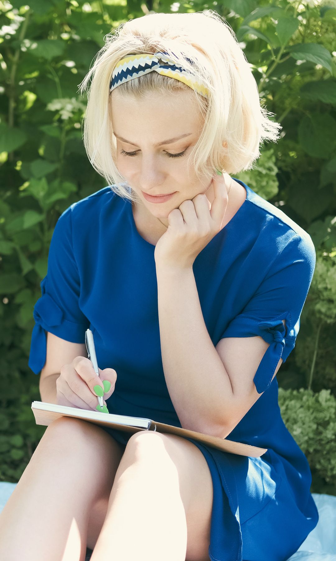 Mujer rubia escribiendo un diario con expresión serena