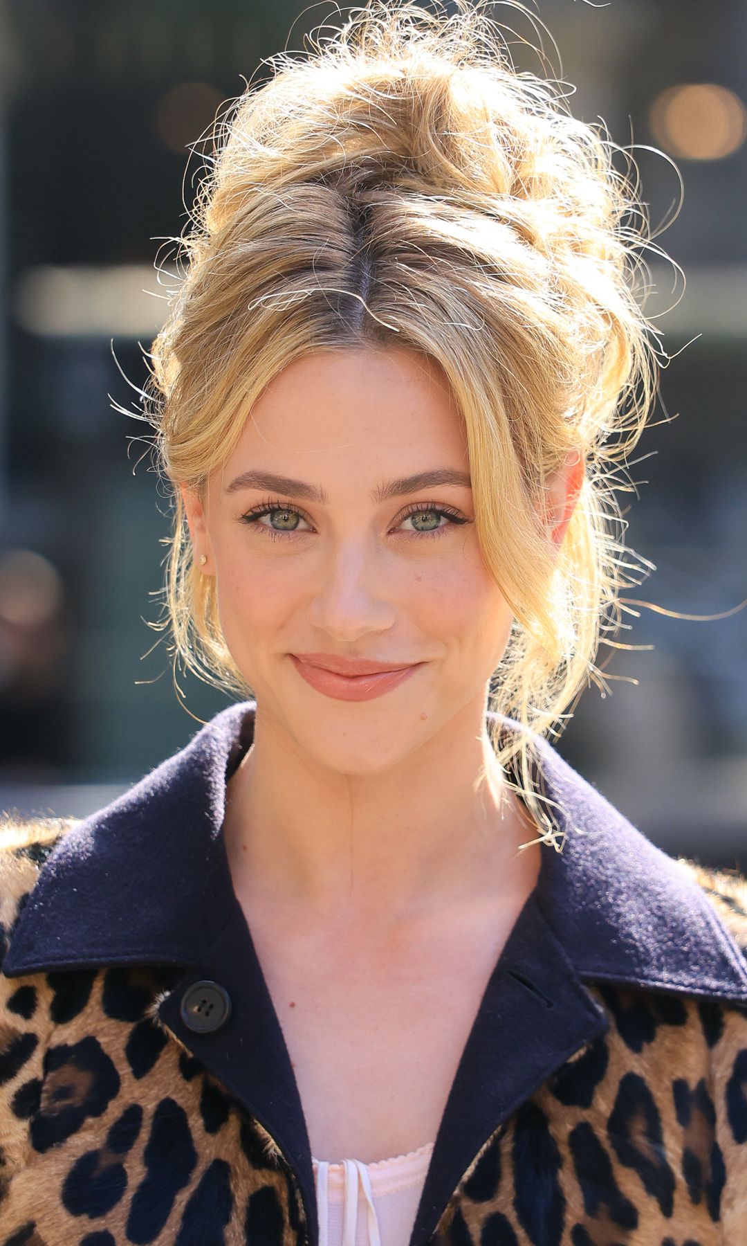Lili Reinhart en el desfile de Miu Miu con moño alto y desenfadado