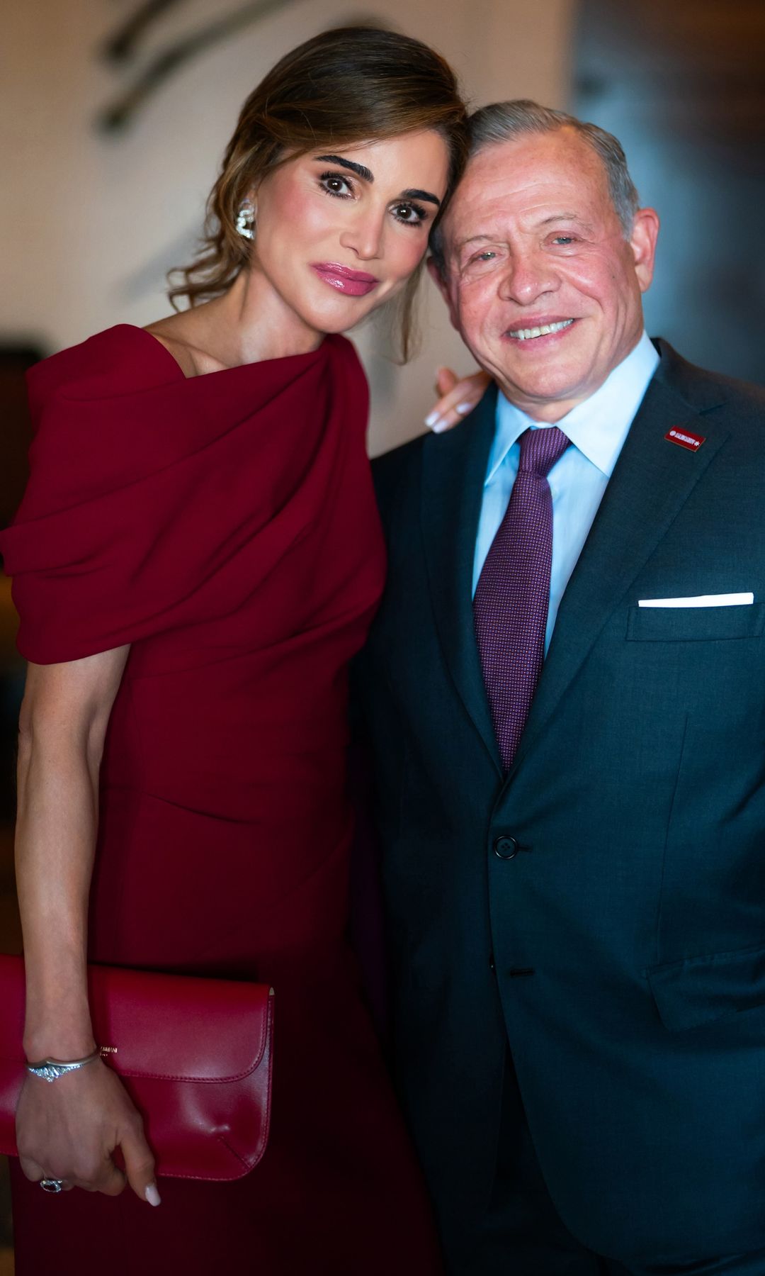 Rania de Jordania deslumbra al ir de boda en Amán con un elegante vestido rojo con capa que eleva su look de invitada
