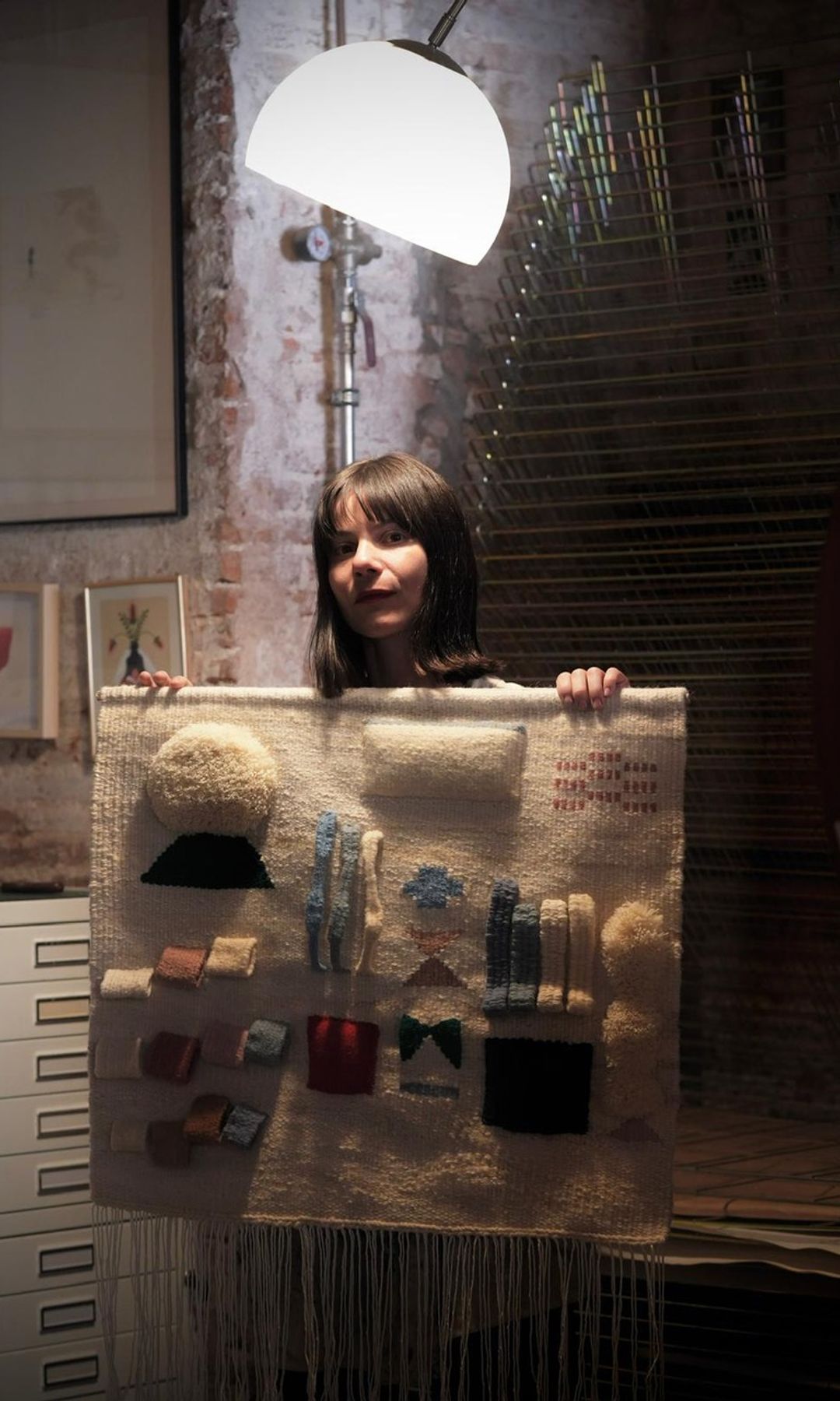 La artista textil Luna Múñoz posando con un tapiz 