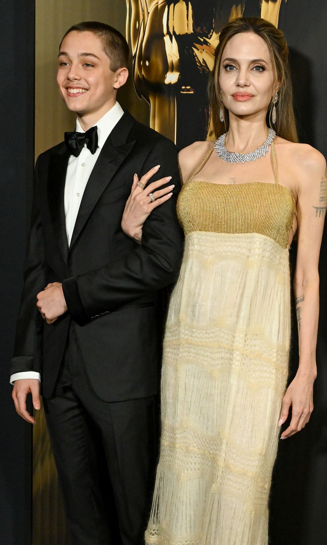 Plano medio de Angelina Jolie y su hijo Knox posando en los Governors Awards 2024
