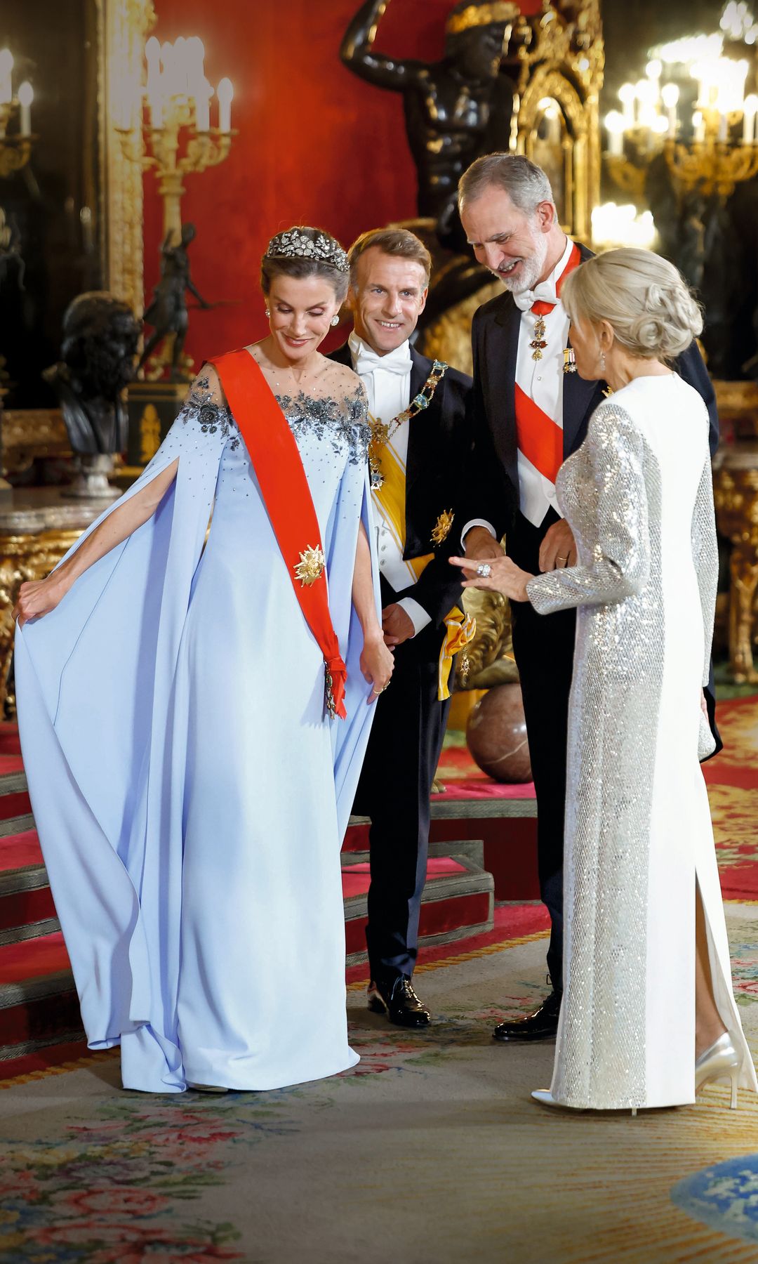 Doña Letizia juega con su vestido y comparte el divertido momento con el rey y el matrimonio presidencial de Francia