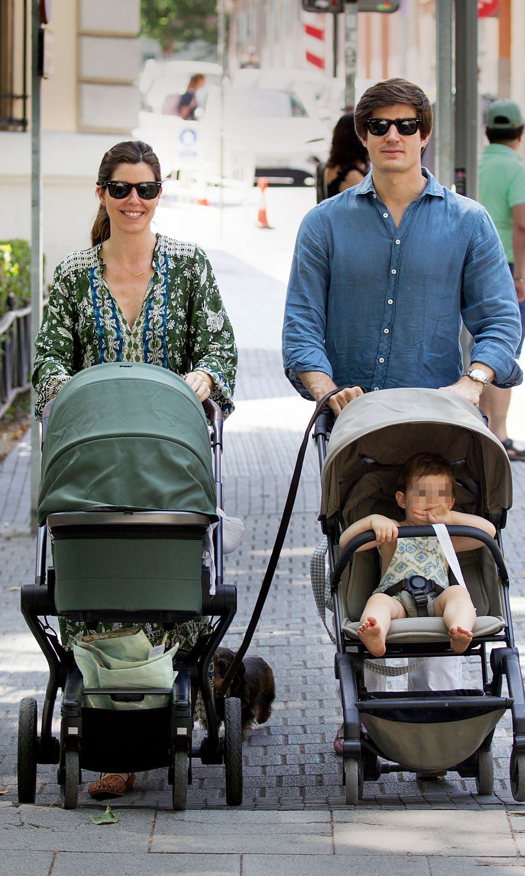 Belén Corsini, con vestido estilo«"boho" de estampado floral y sandalias planas, pasea a su segundo hijo, que acaba de cumplir su primer mes de vida. A su lado, su marido, Carlos Fitz-James, lleva a su hijo mayor, Carlos, de un año