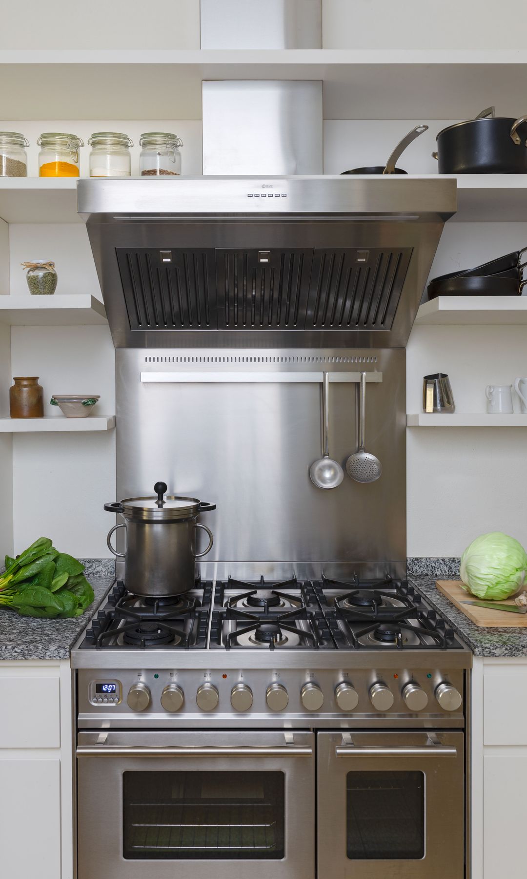 Cocina de acero de fuego, con horno y campana integrada, baldas de madera blanca