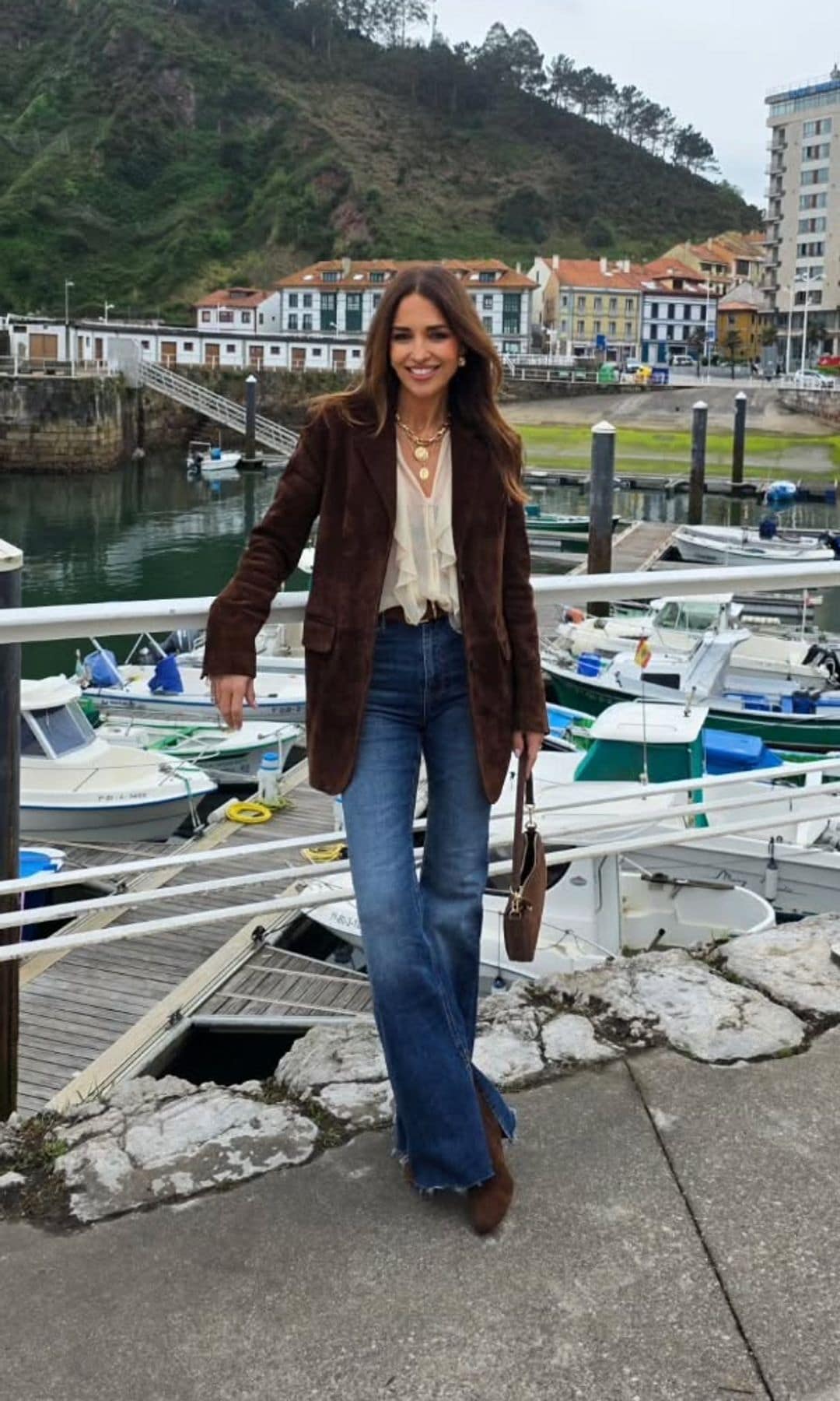 Paula Echevarría con vaqueros acampanados, blusa blanca, botines y americana marrón en Asturias