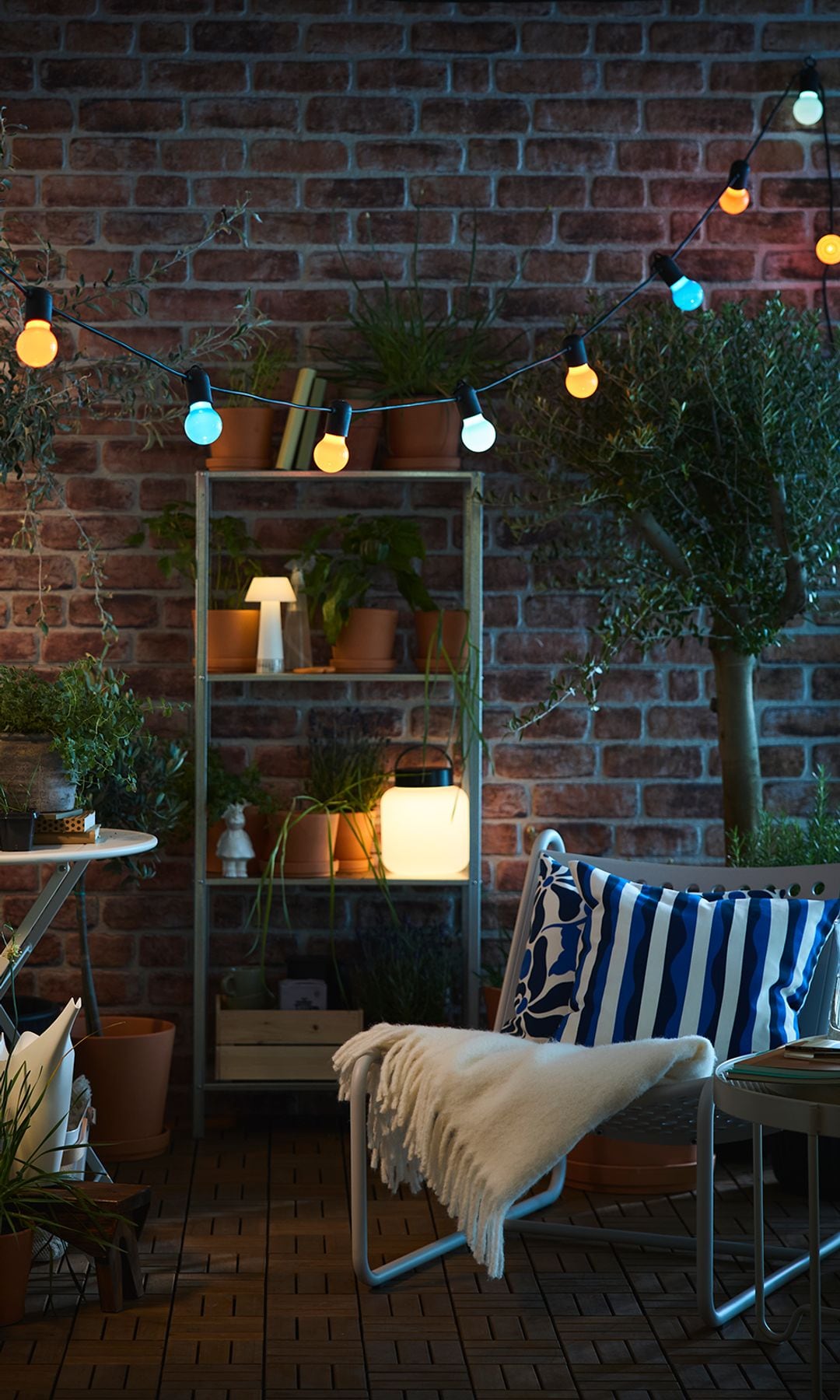 Terraza con muebles y guirnalda de luces de IKEA