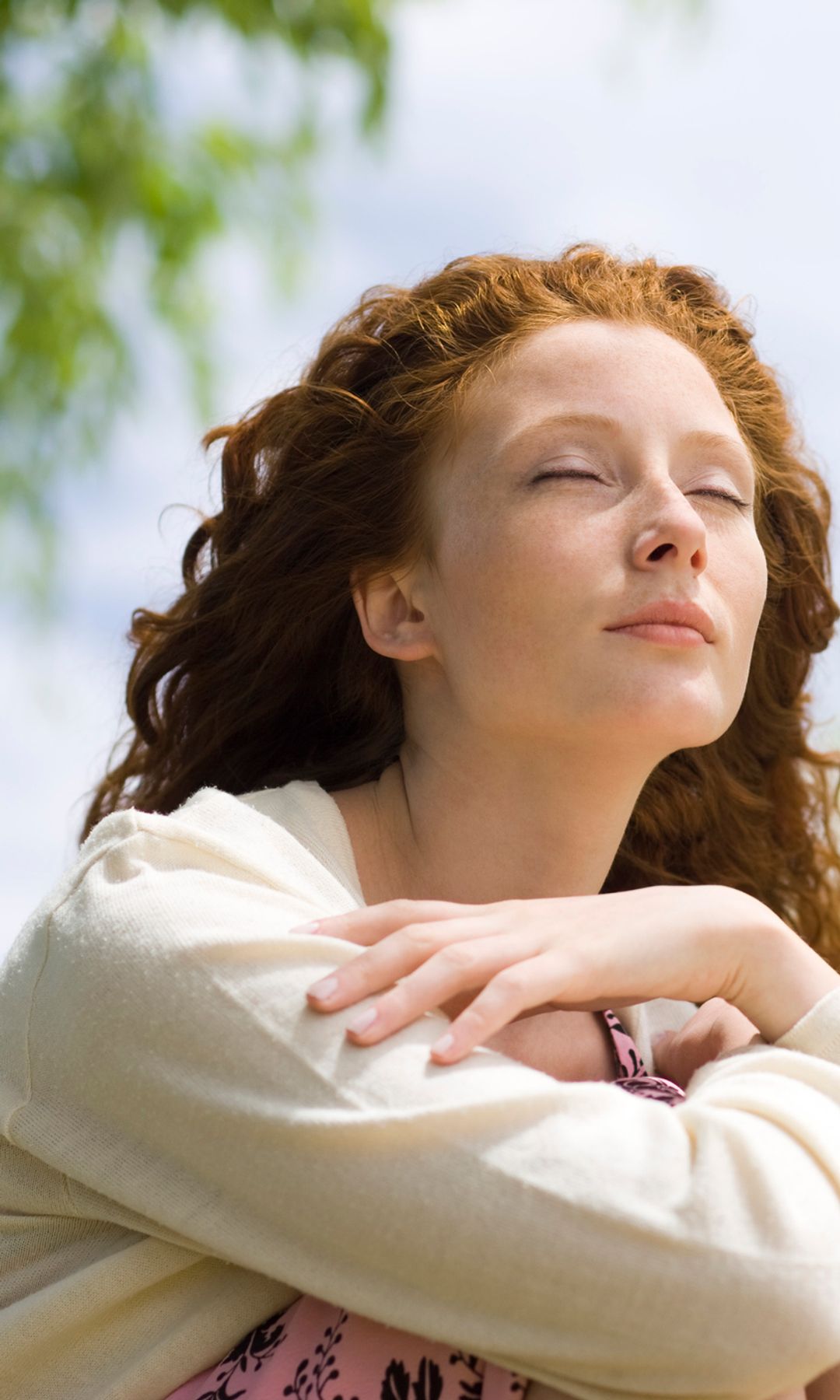 Mujer pelirroja con los ojos cerrados y respirando