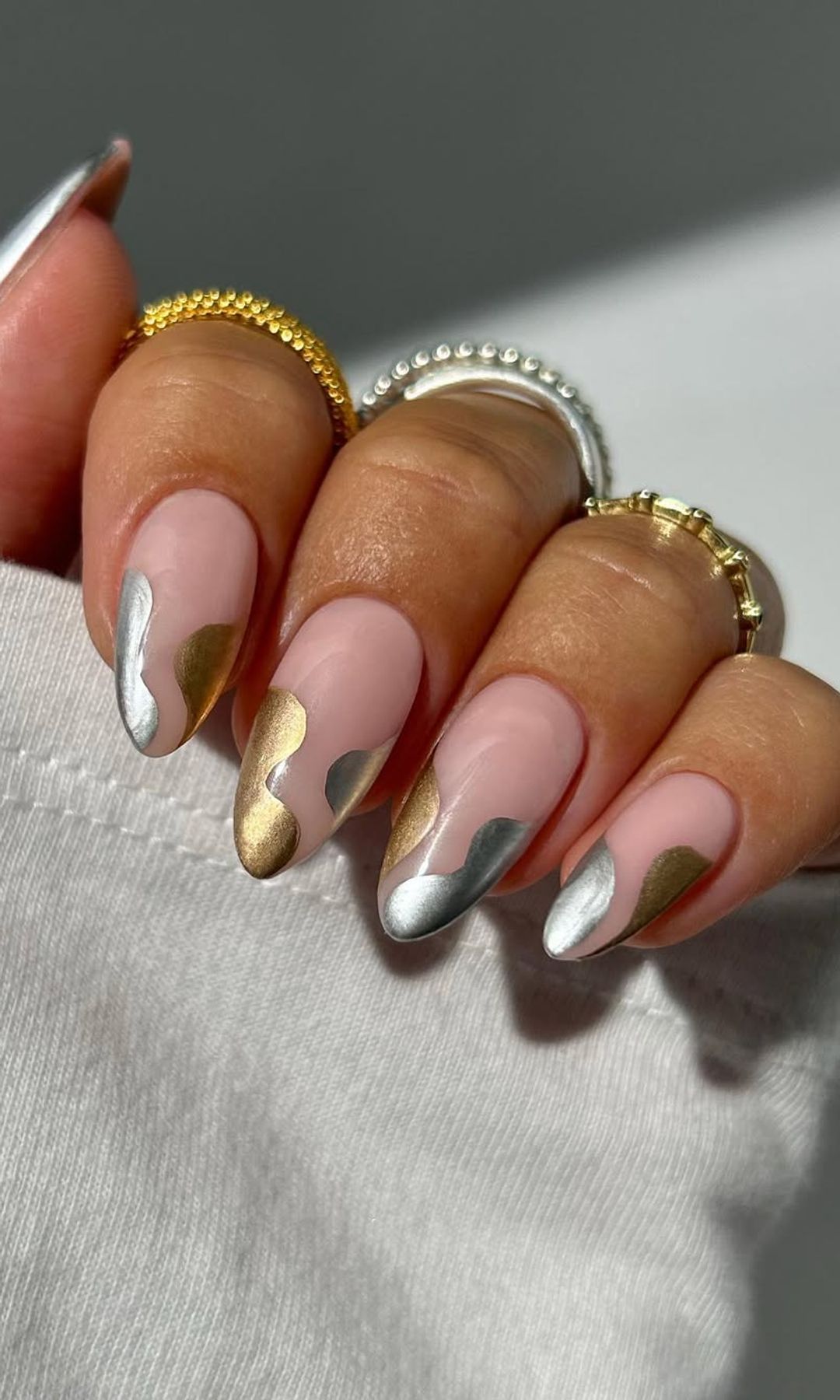 Manicura con ondas abstractas en plateado y dorado
