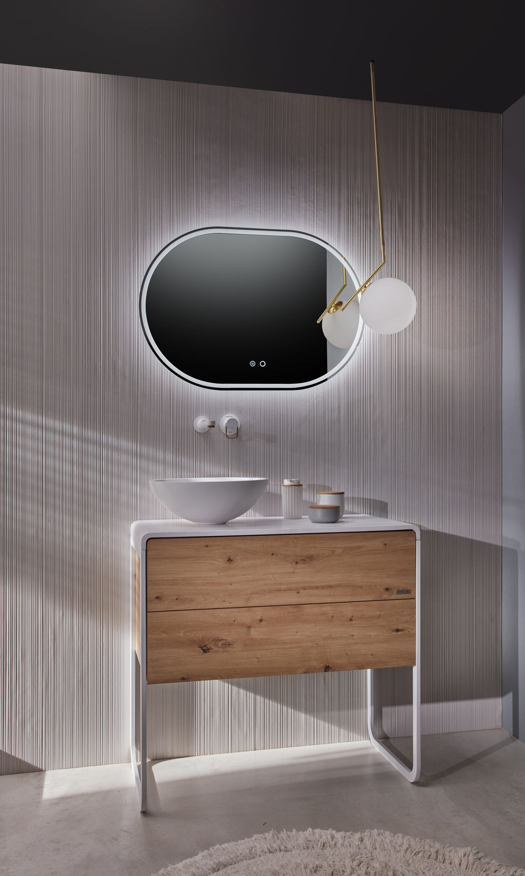 Baño con mueble de lavabo de madera, lavabo sobre la encimera, espejo retroiluminado y lámpara de techo