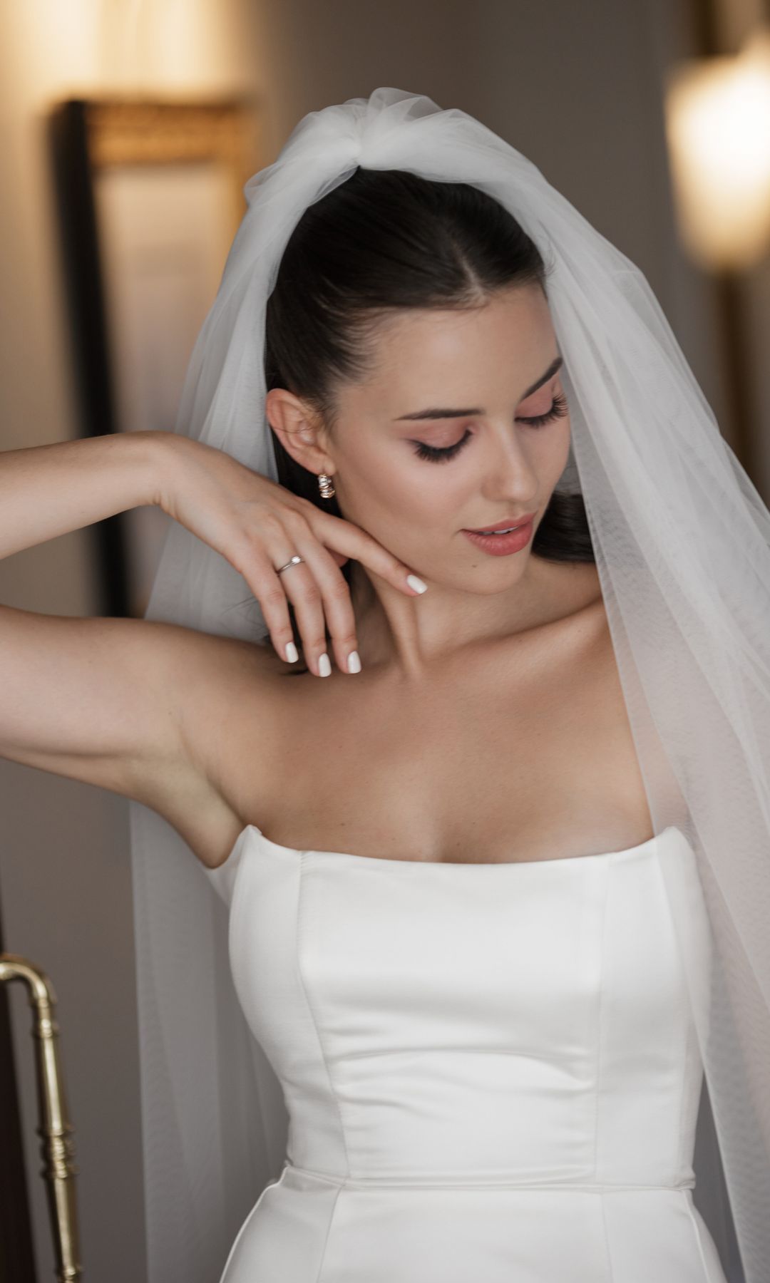 Joven morena y grácil con un elegante vestido de novia
