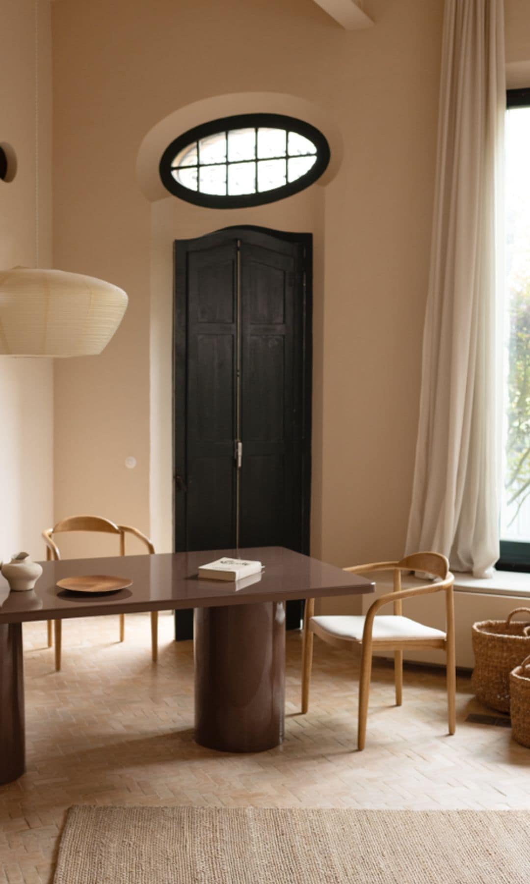 Comedor con cortina apoyada sobre el mueble delante de la ventana