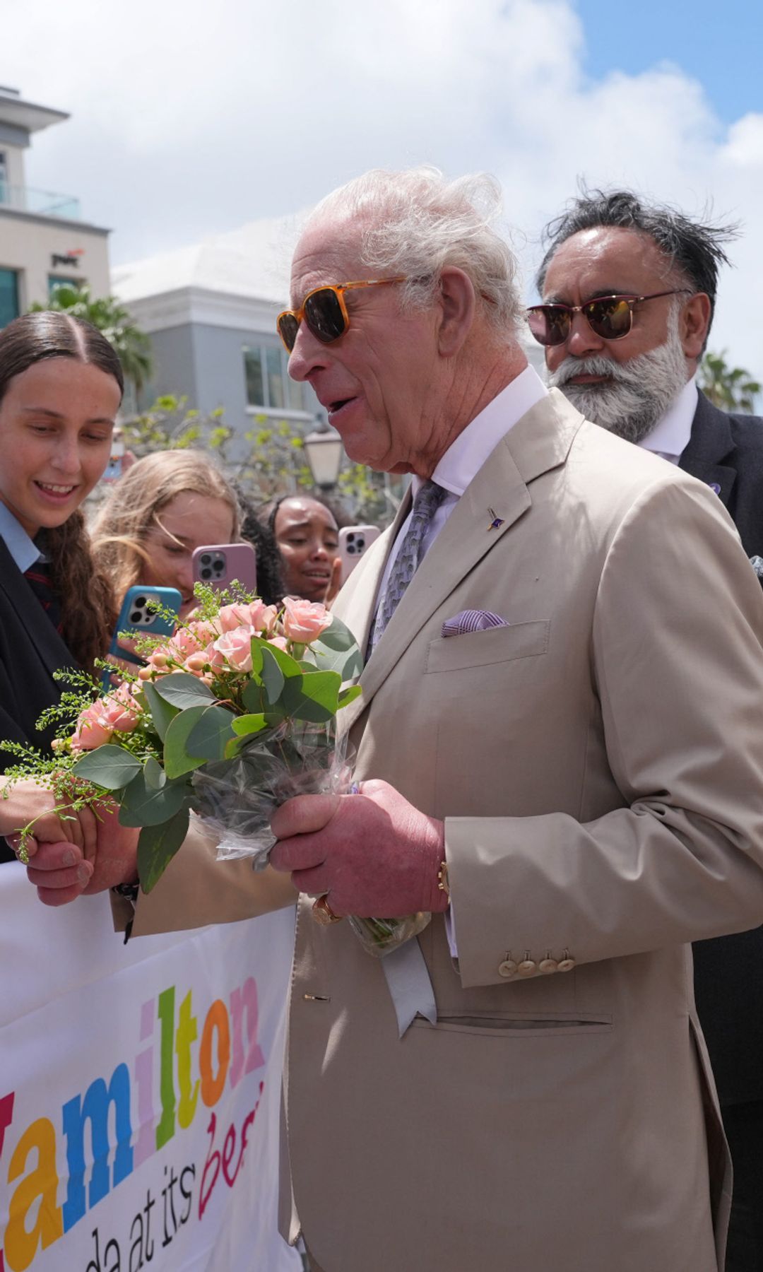 El rey Carlos III saluda a la gente congregada en las calles durante su visita al Ayuntamiento y al Centro de Artes de Hamilton
