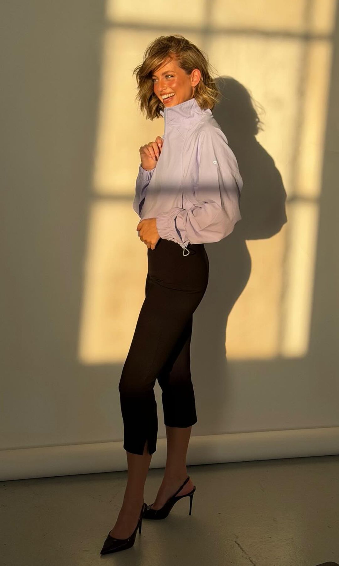 Magui Corceiro con pantalones capri negros y chaqueta de Alo 