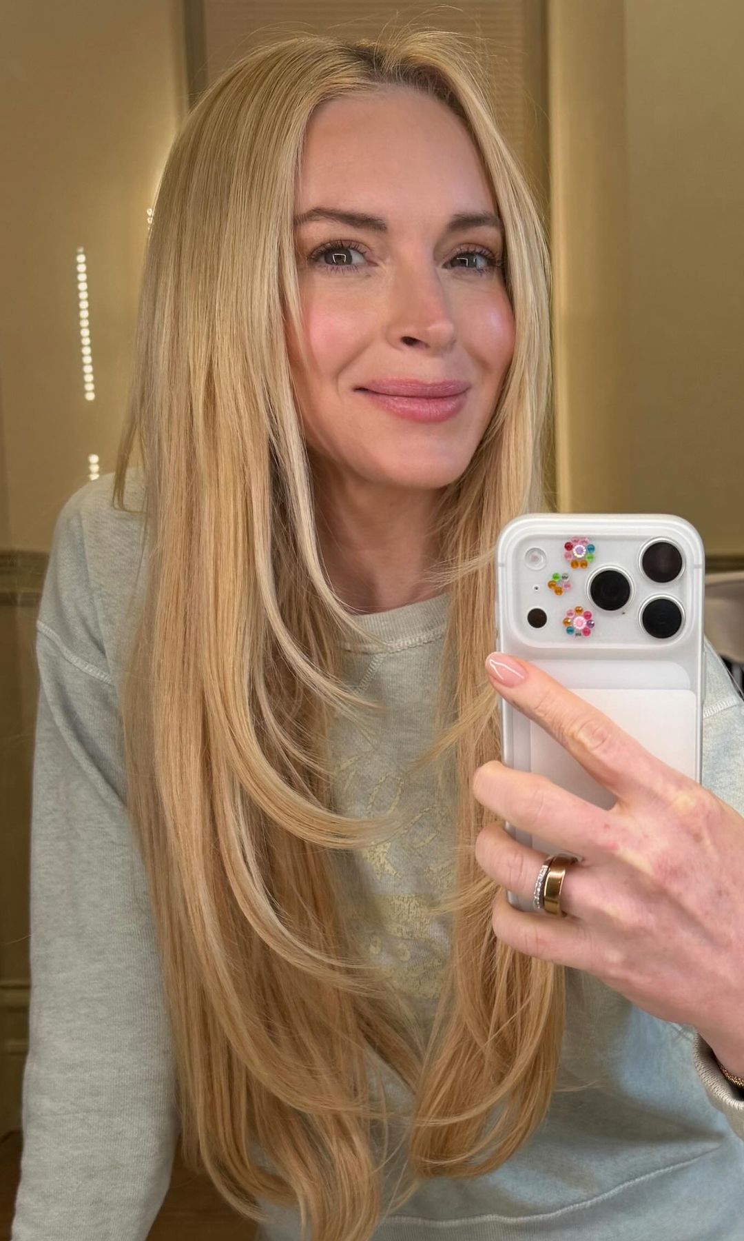 Lindsay Lohan se hace un selfie frente al espejo con pelo largo y suelto rubio, chándal gris