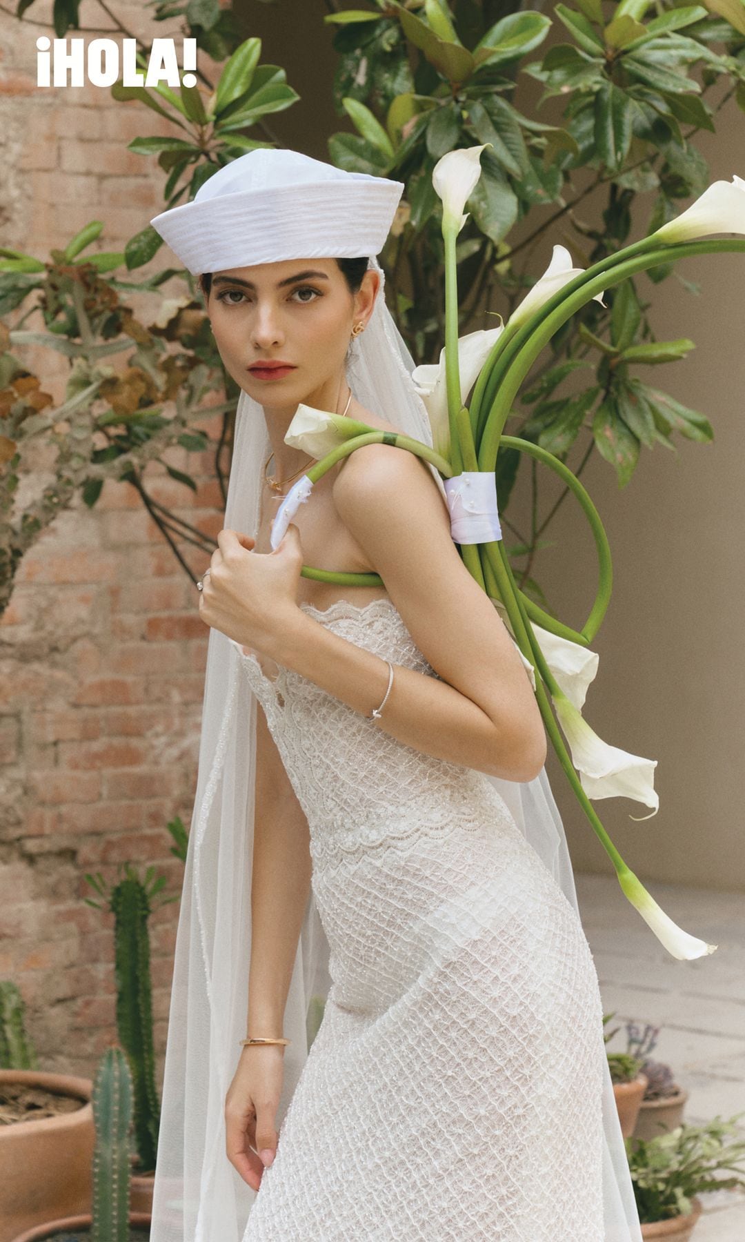En esta imagen, la novia luce vestido y velo de Rosa Clará, acompañado por un brazalete Lock con pavé de diamantes, y aretes y collar Knot en oro rosa con diamantes, de Tiffany & Co. El ramo —como todos los de esta editorial— es de Polen Flores.