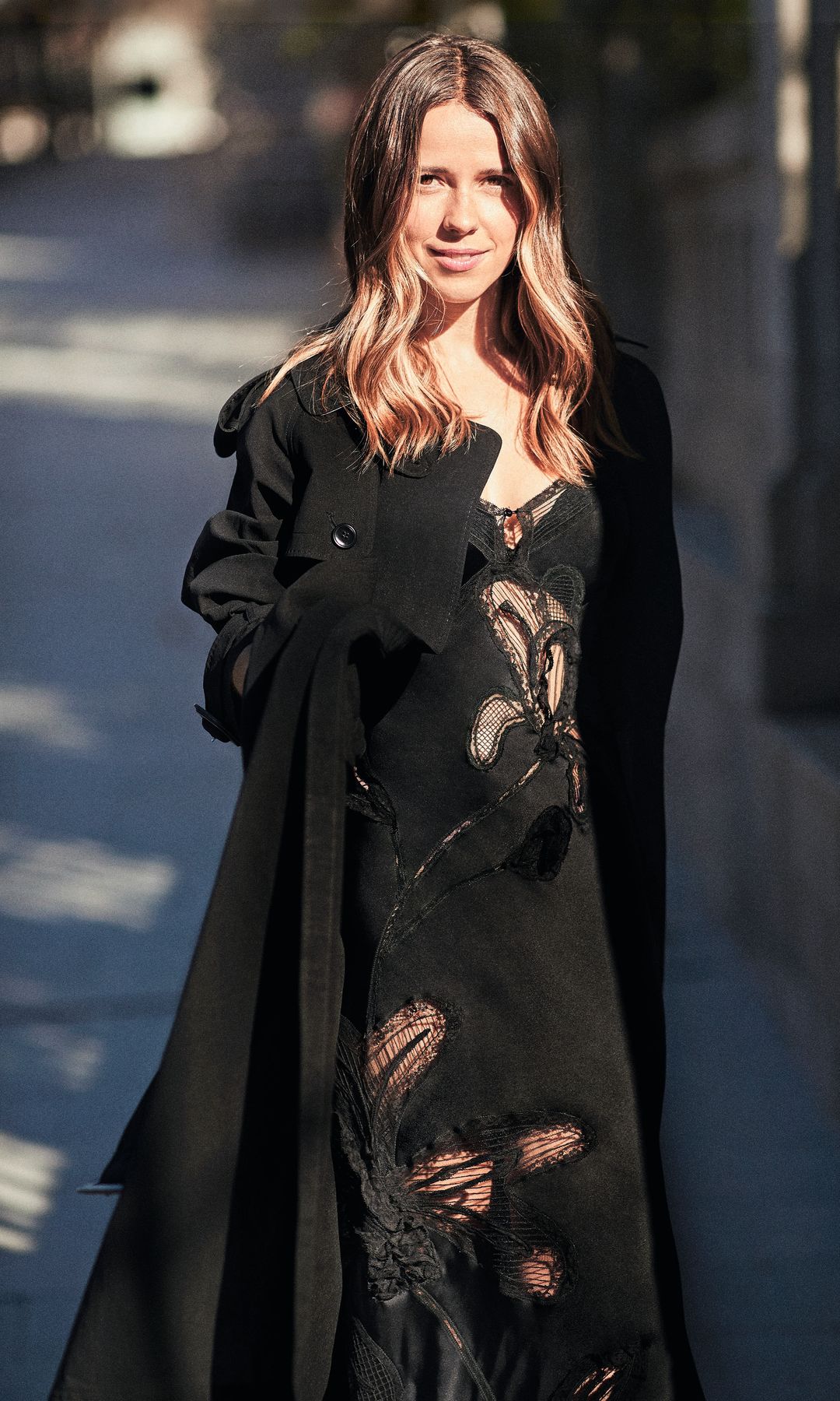 La actriz Ana Jara con cabello largo rubio, sonriendo y vistiendo un abrigo negro con detalles florales.