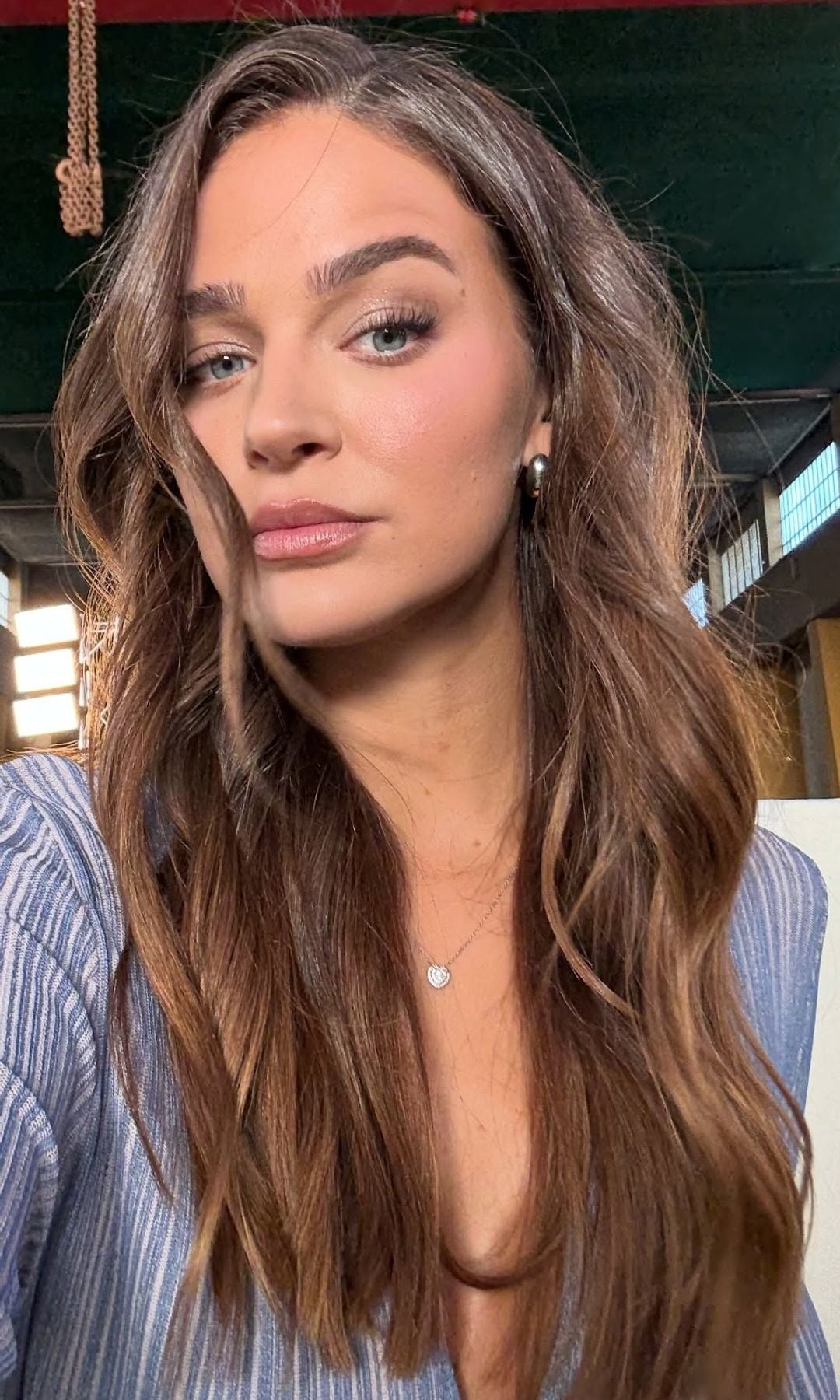 Laura Escanes en 2025 con camisa milrrayas azul y blanca y pelo largo ondulado